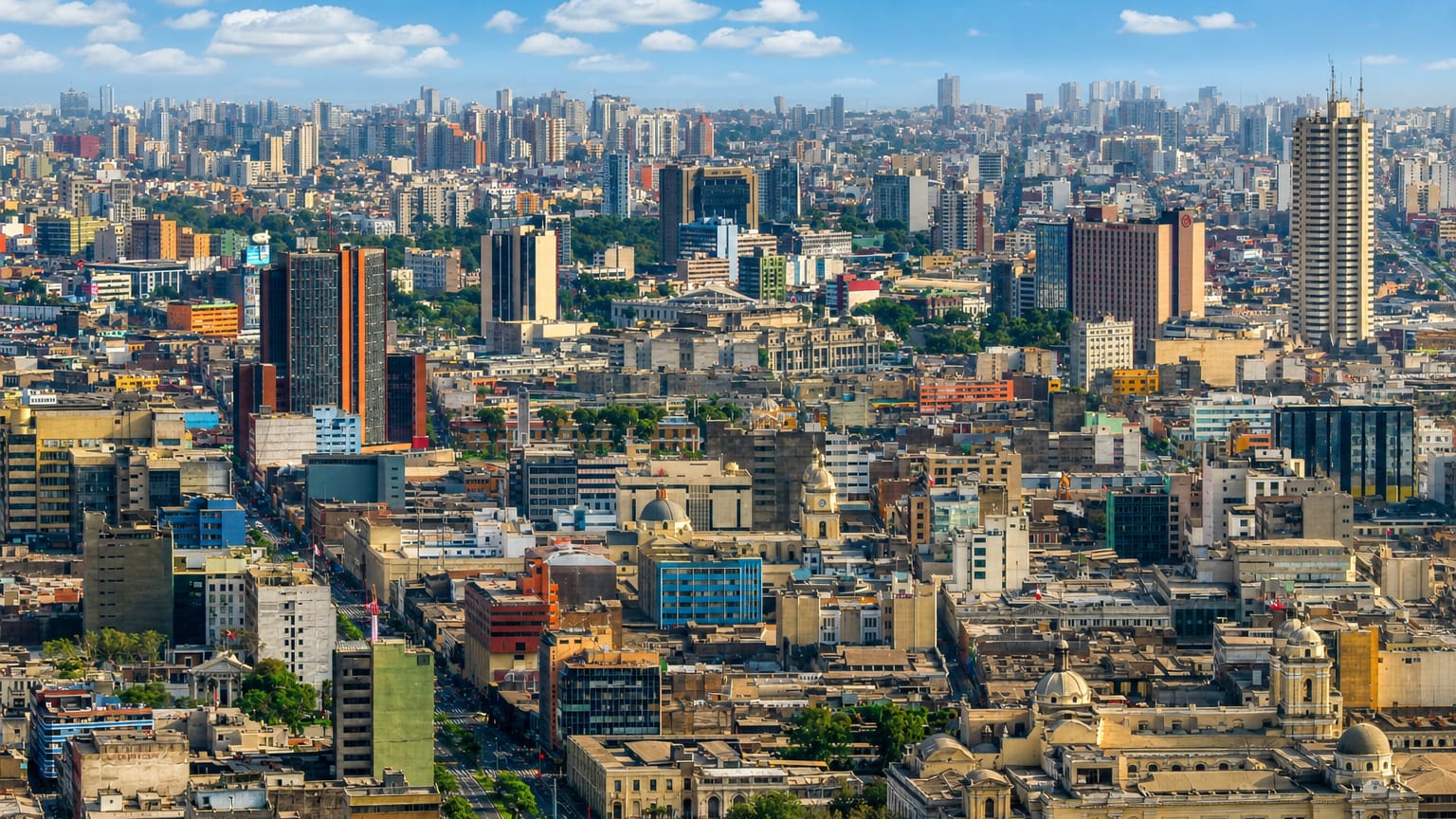 Dense daytime skyline of central Lima with high-rises and historic buildings under a blue sky