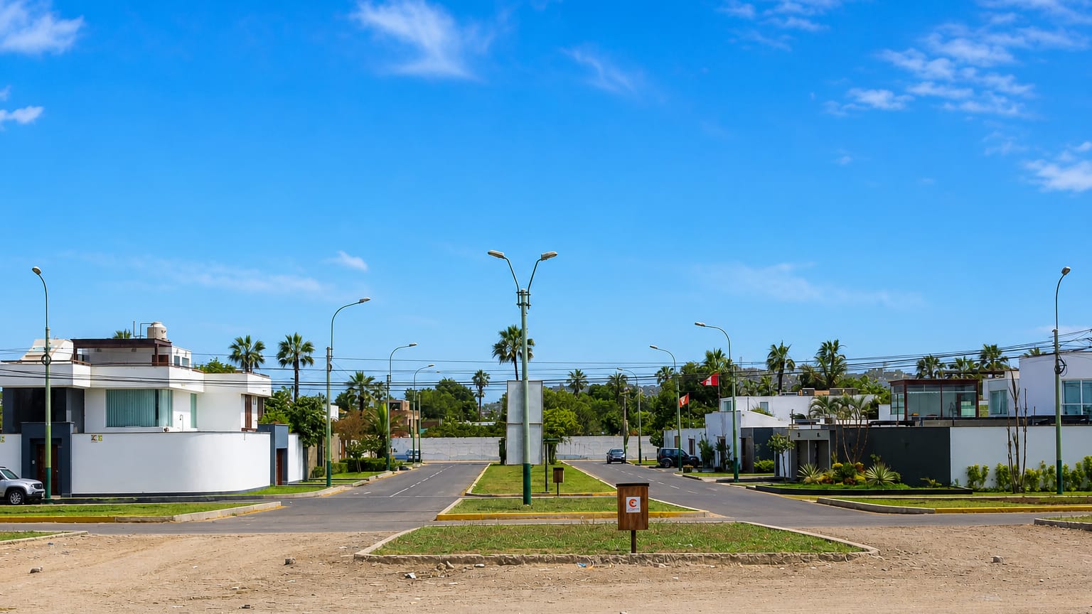 Modern white houses and palm trees along a wide boulevard in the La Encantada de Villa area of Lima