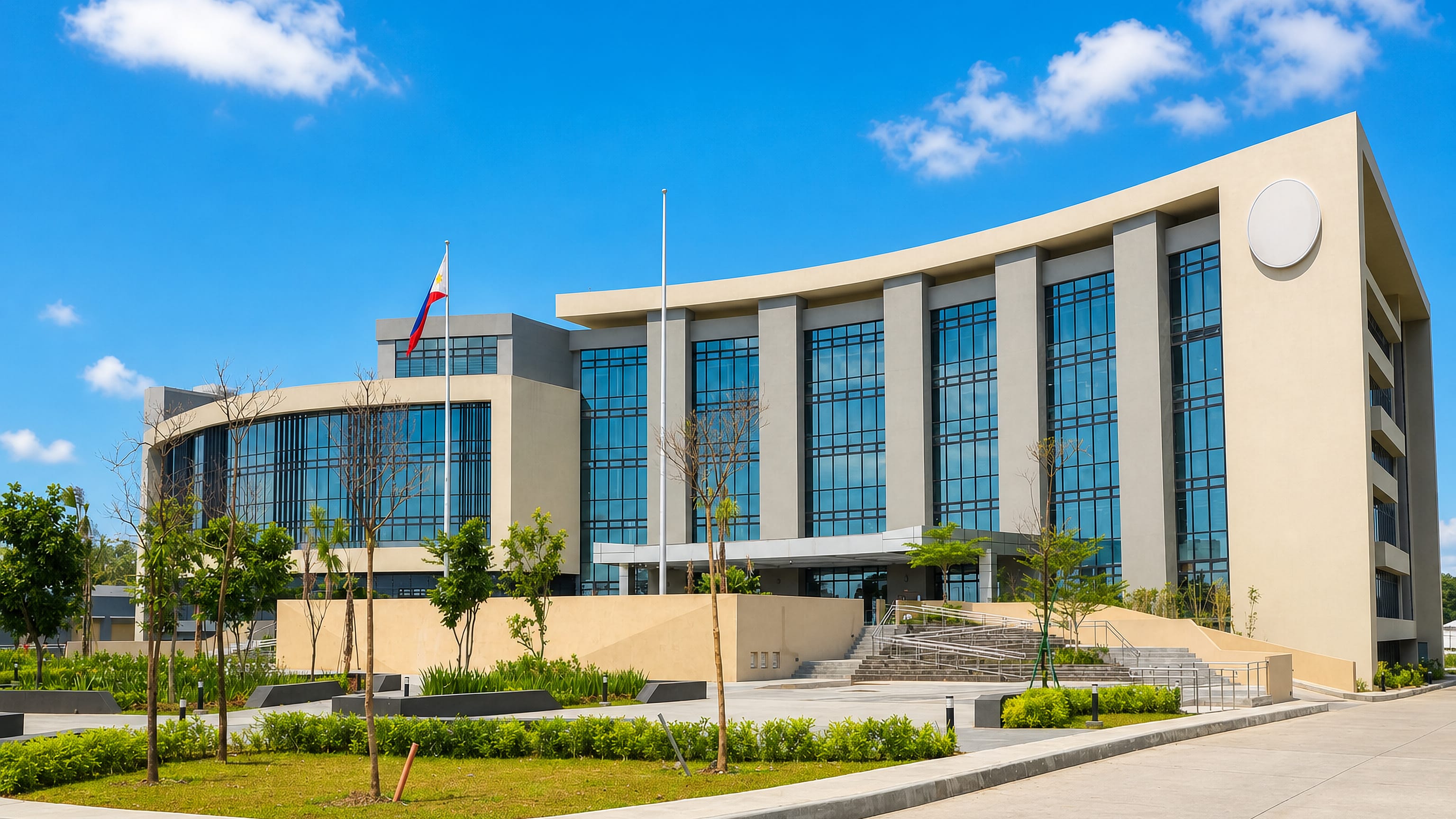 Modern civic building flying the Philippine flag in Imus, Cavite, on a clear day.