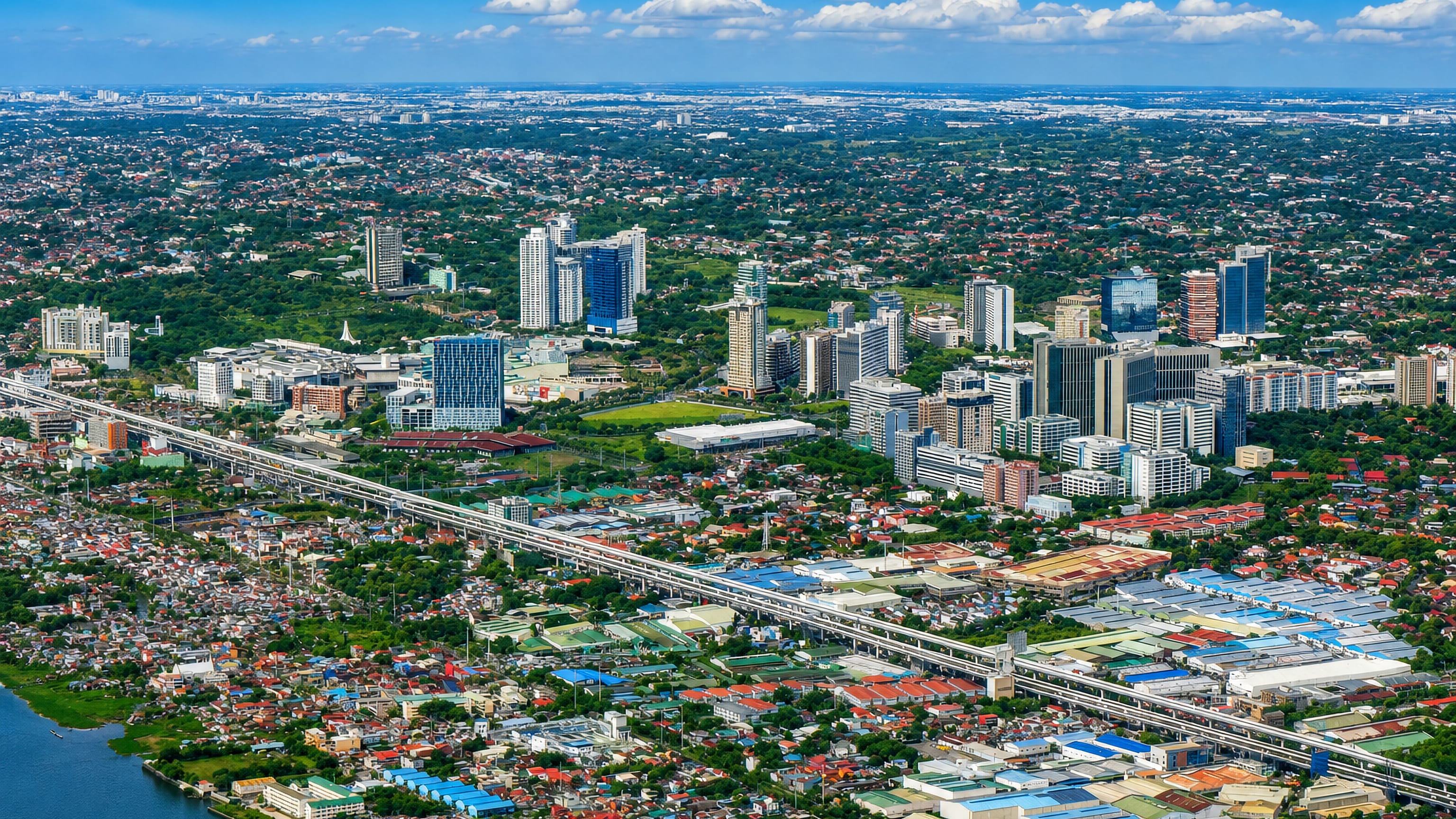 Muntinlupa's high-rise business district beside the elevated Skyway, with Laguna de Bay at its edge.