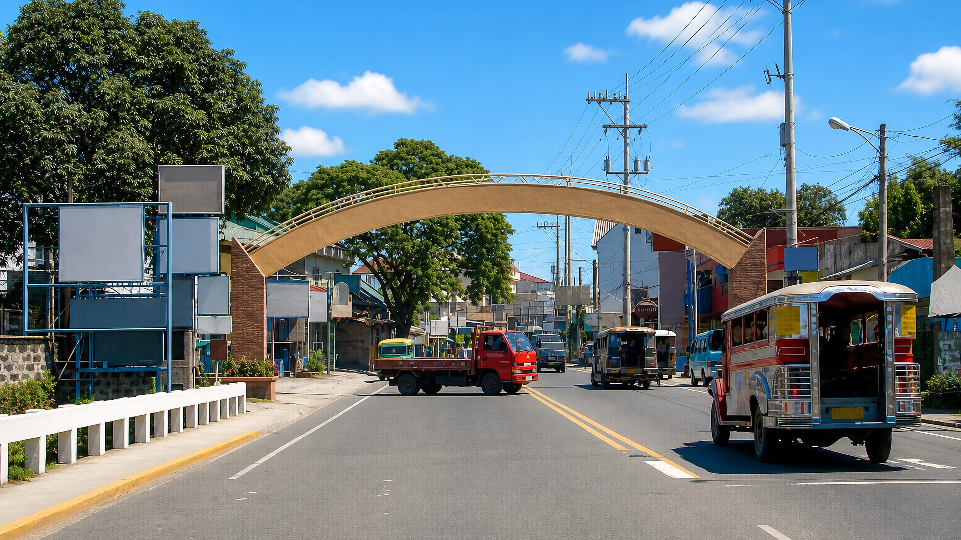 A welcome arch over the main road into San Mateo, Philippines, with a jeepney and truck passing beneath.