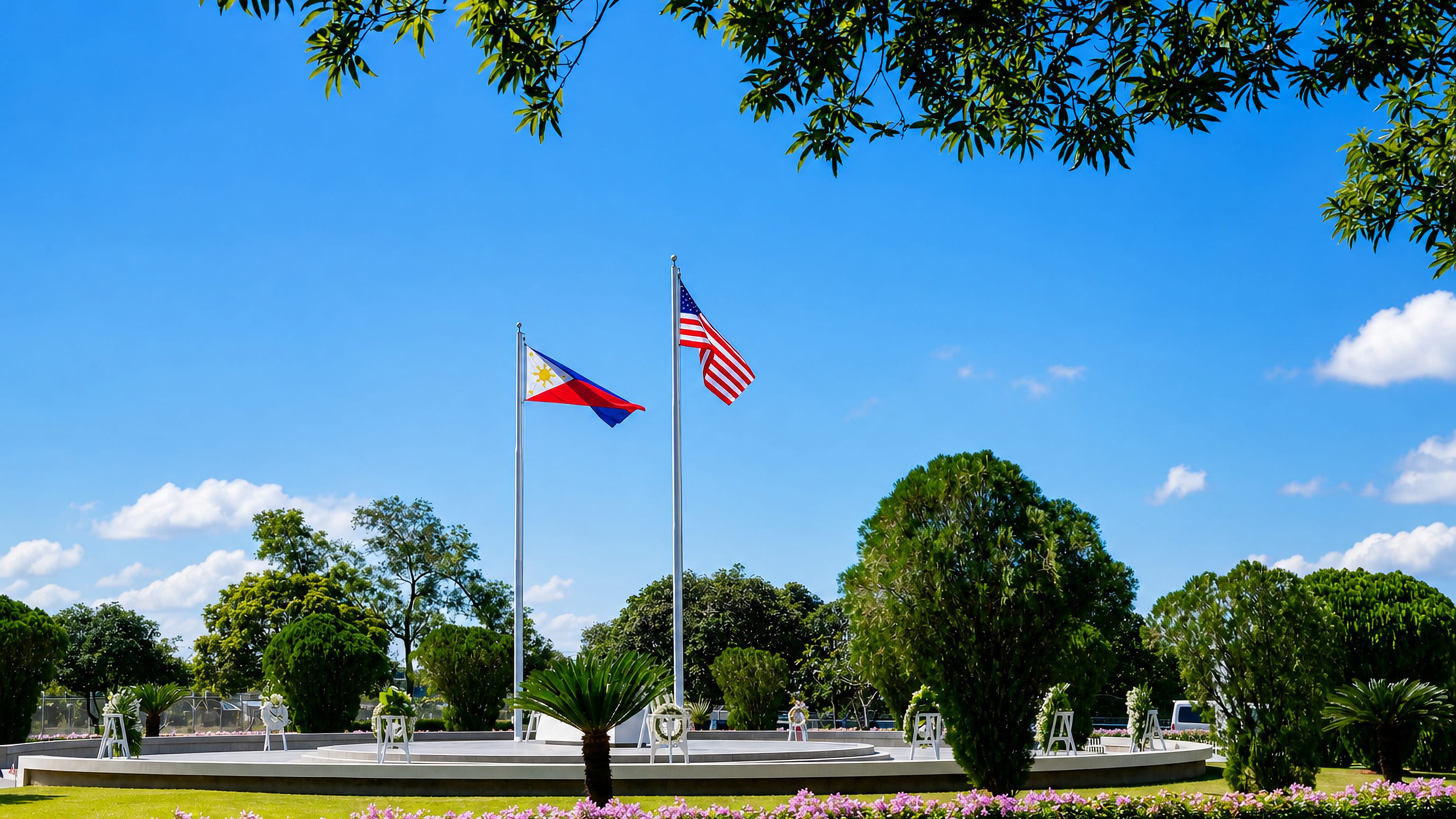 Philippine and US flags over a landscaped memorial plaza in Cabanatuan City, Nueva Ecija.