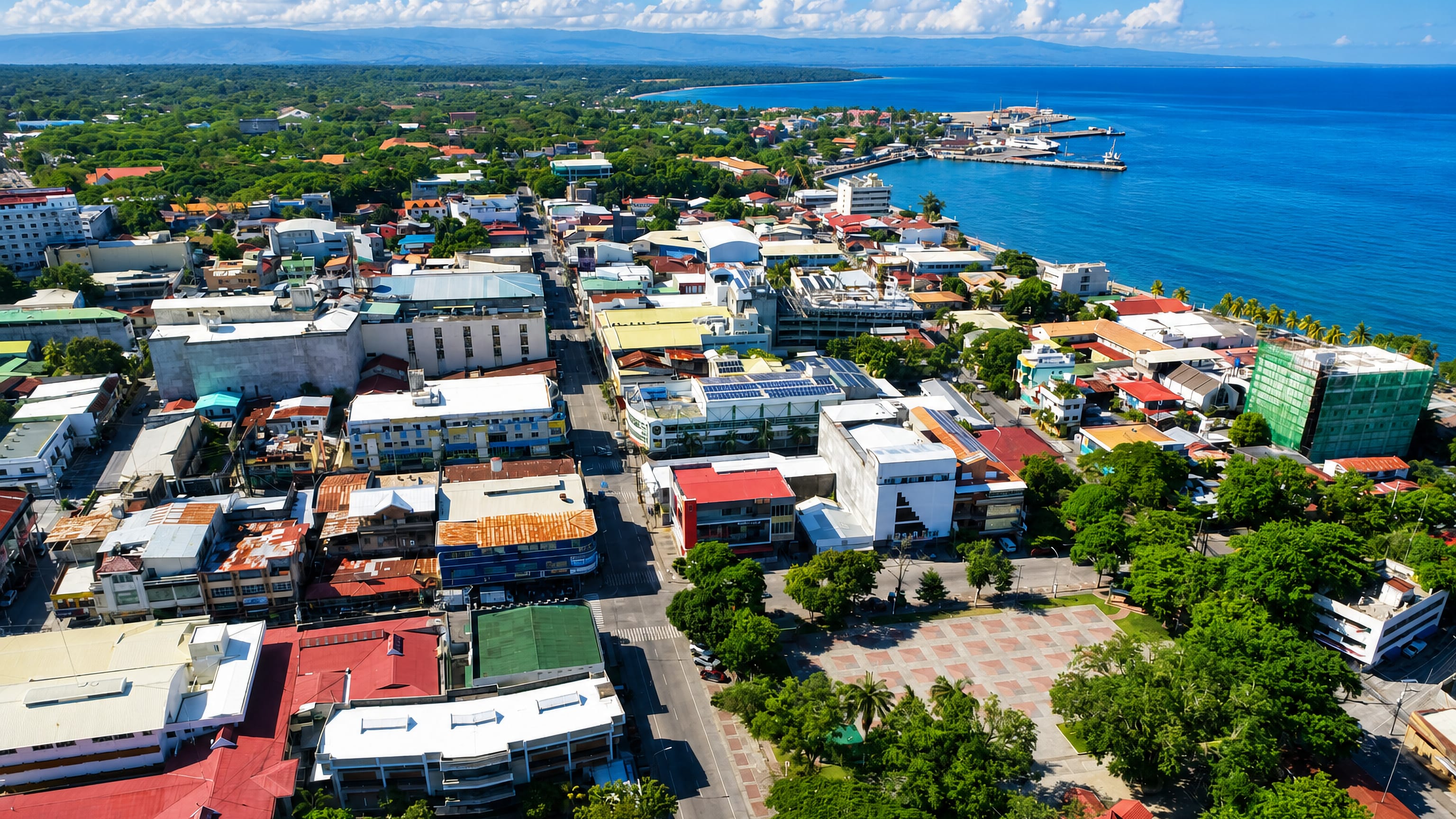 Aerial view of Dumaguete, Philippines, its downtown rooftops, seafront boulevard and pier on the Bohol Sea.