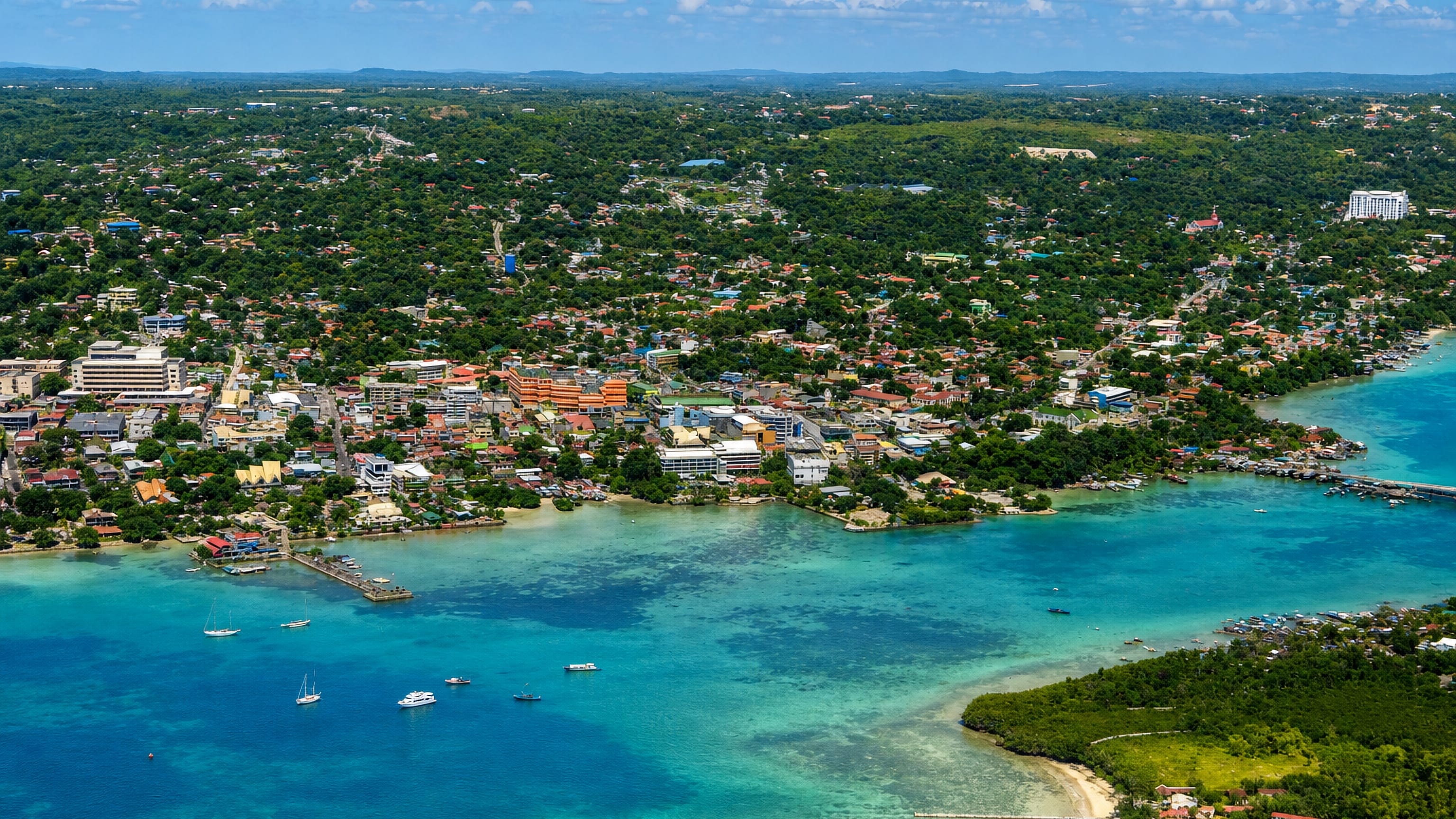 Aerial view of Tagbilaran City on Bohol, its low-rise waterfront meeting the turquoise Bohol Strait
