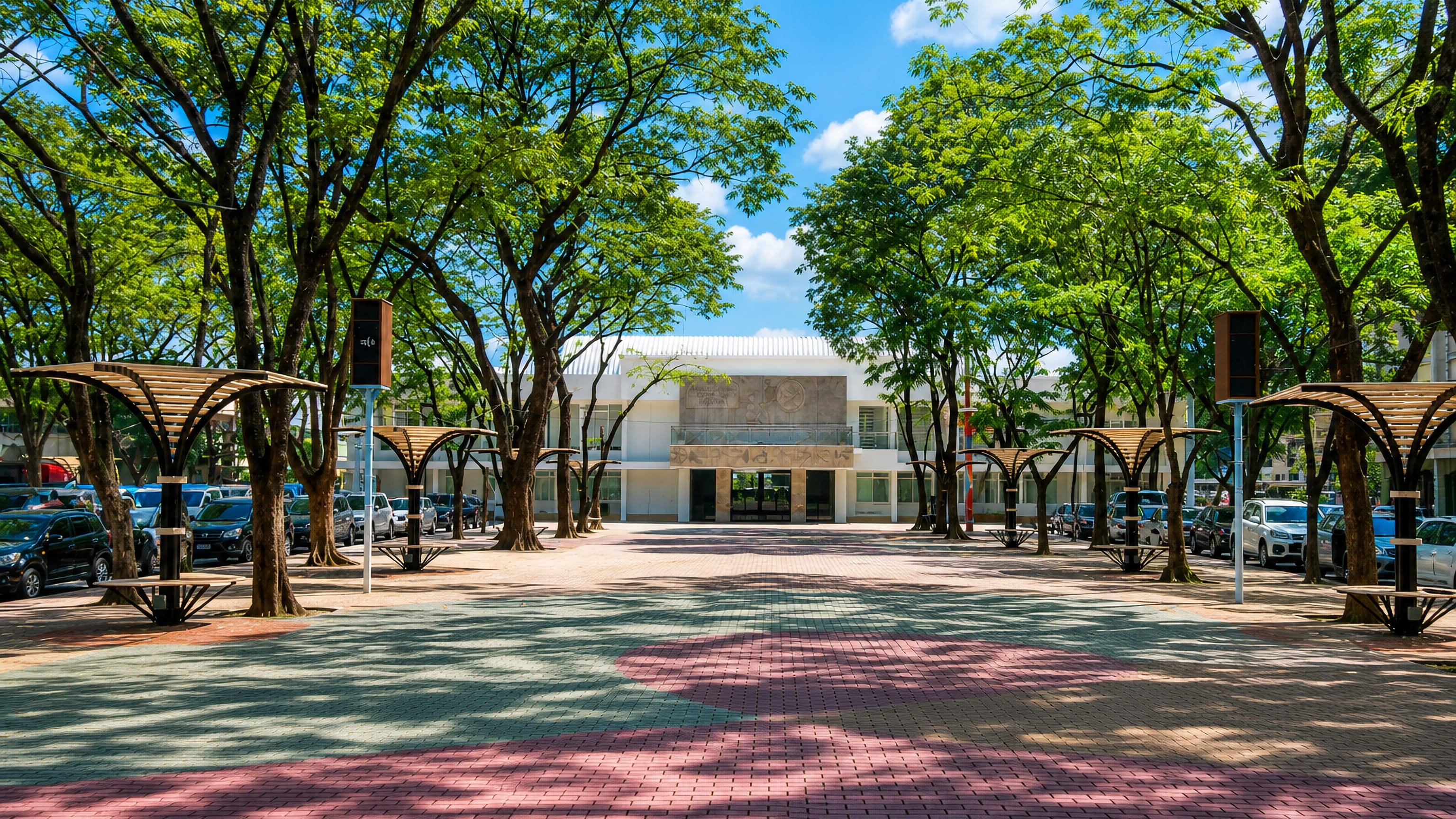 Tree-shaded brick plaza and low modernist civic building in Marikina City, Metro Manila.