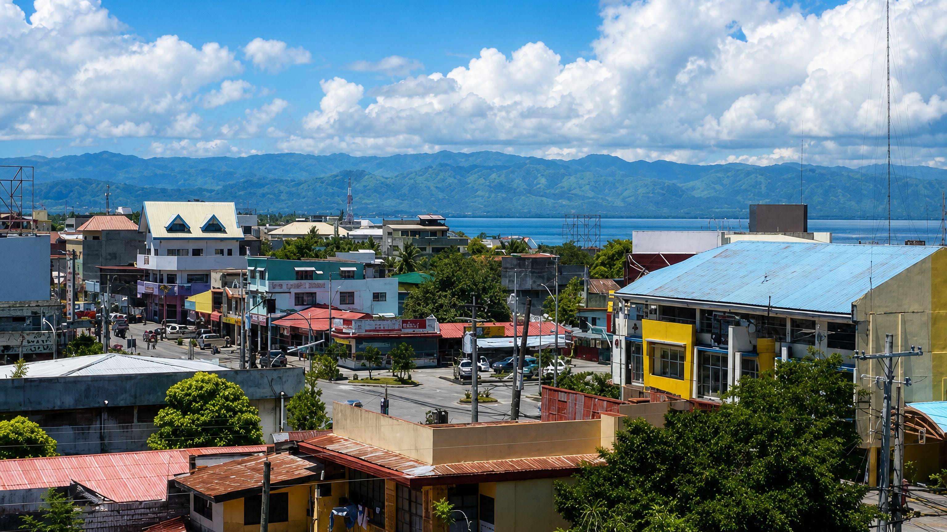 Colourful low-rise streets of General Santos, Philippines, with Sarangani Bay and green mountains beyond