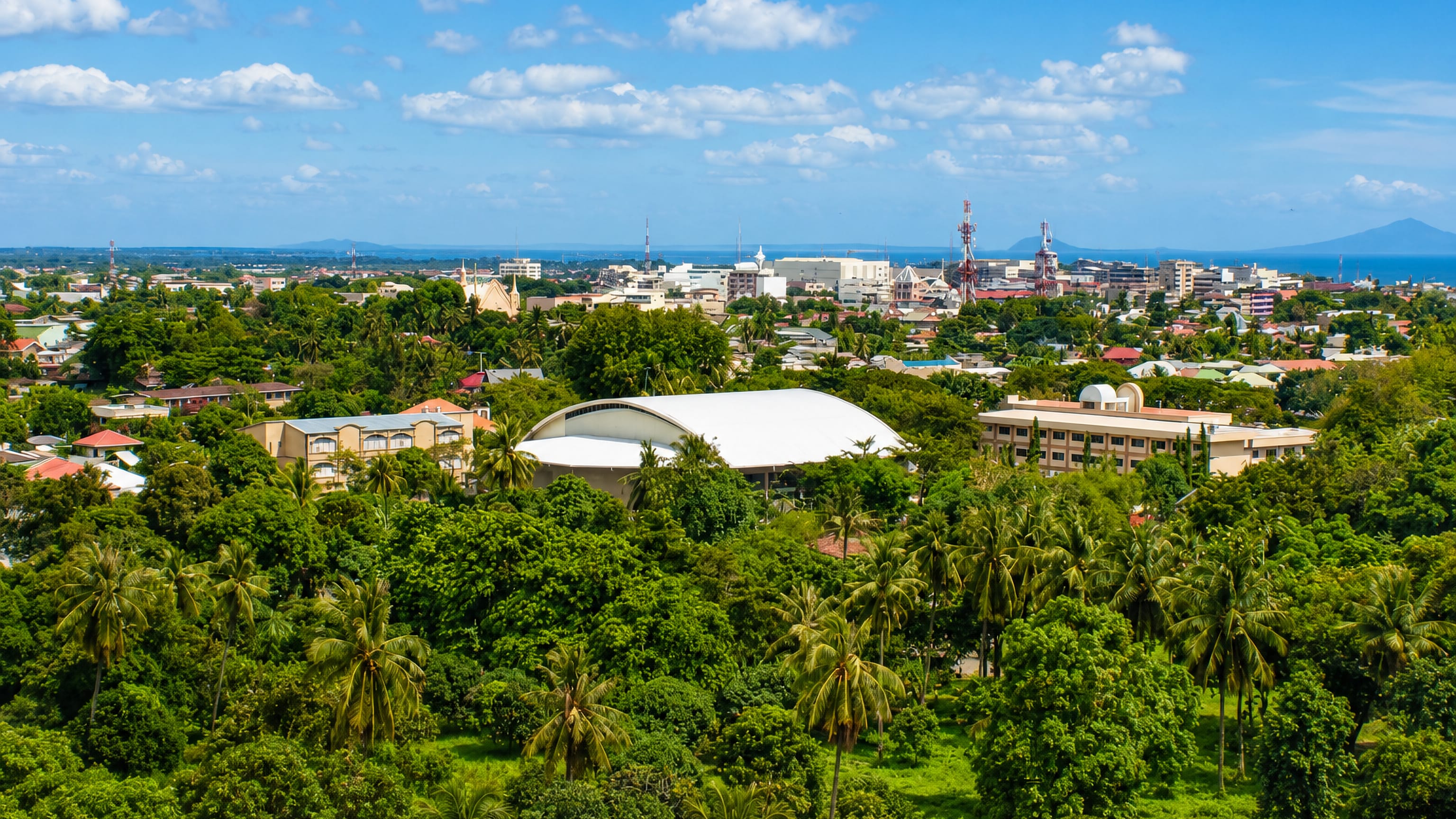 Zamboanga City, Philippines from a hillside: palm-filled neighbourhoods, a domed arena and the Sulu Sea beyond