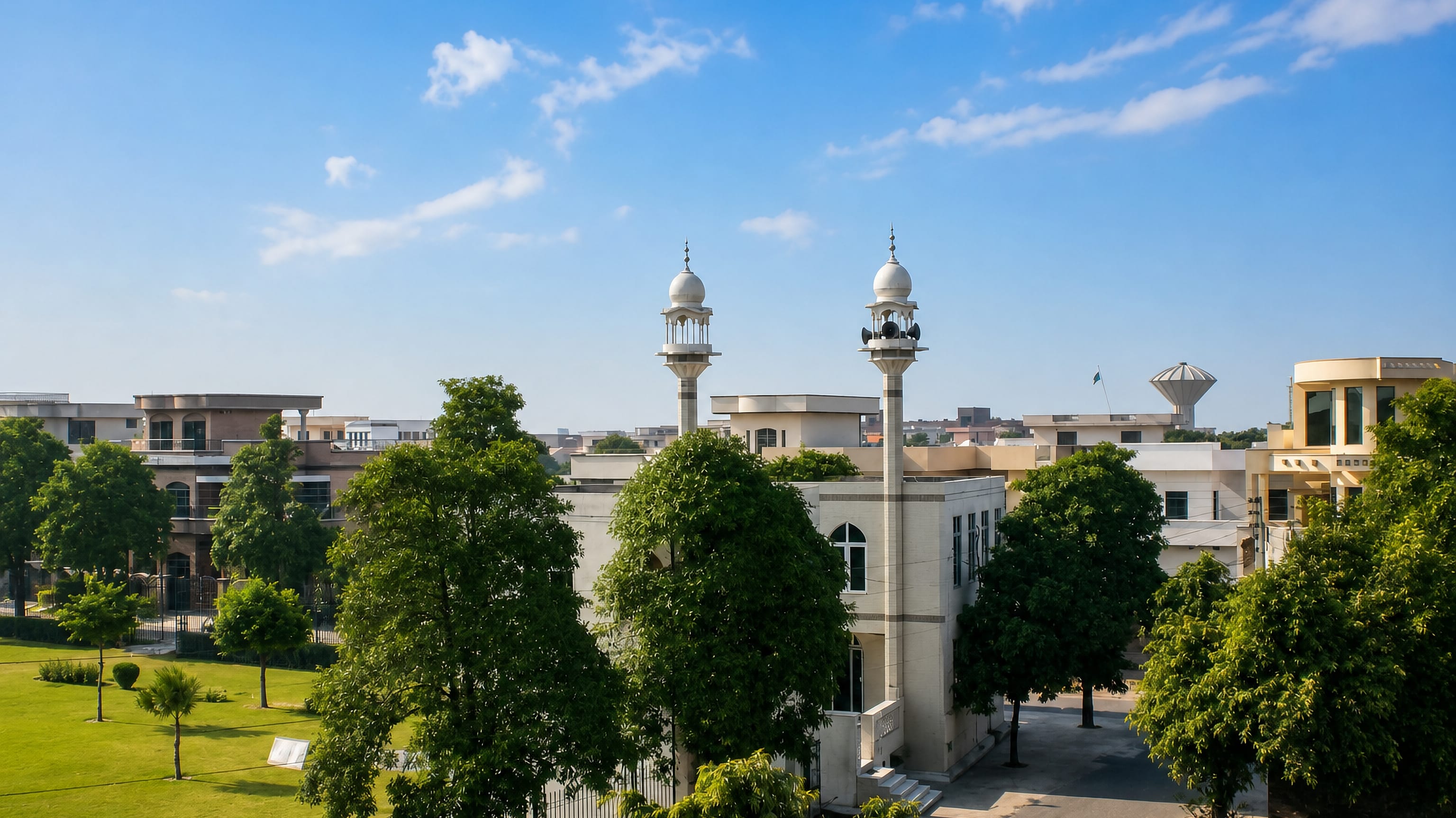 A twin-minaret mosque among trees and lawns in a residential quarter of Gujranwala, Punjab, Pakistan.