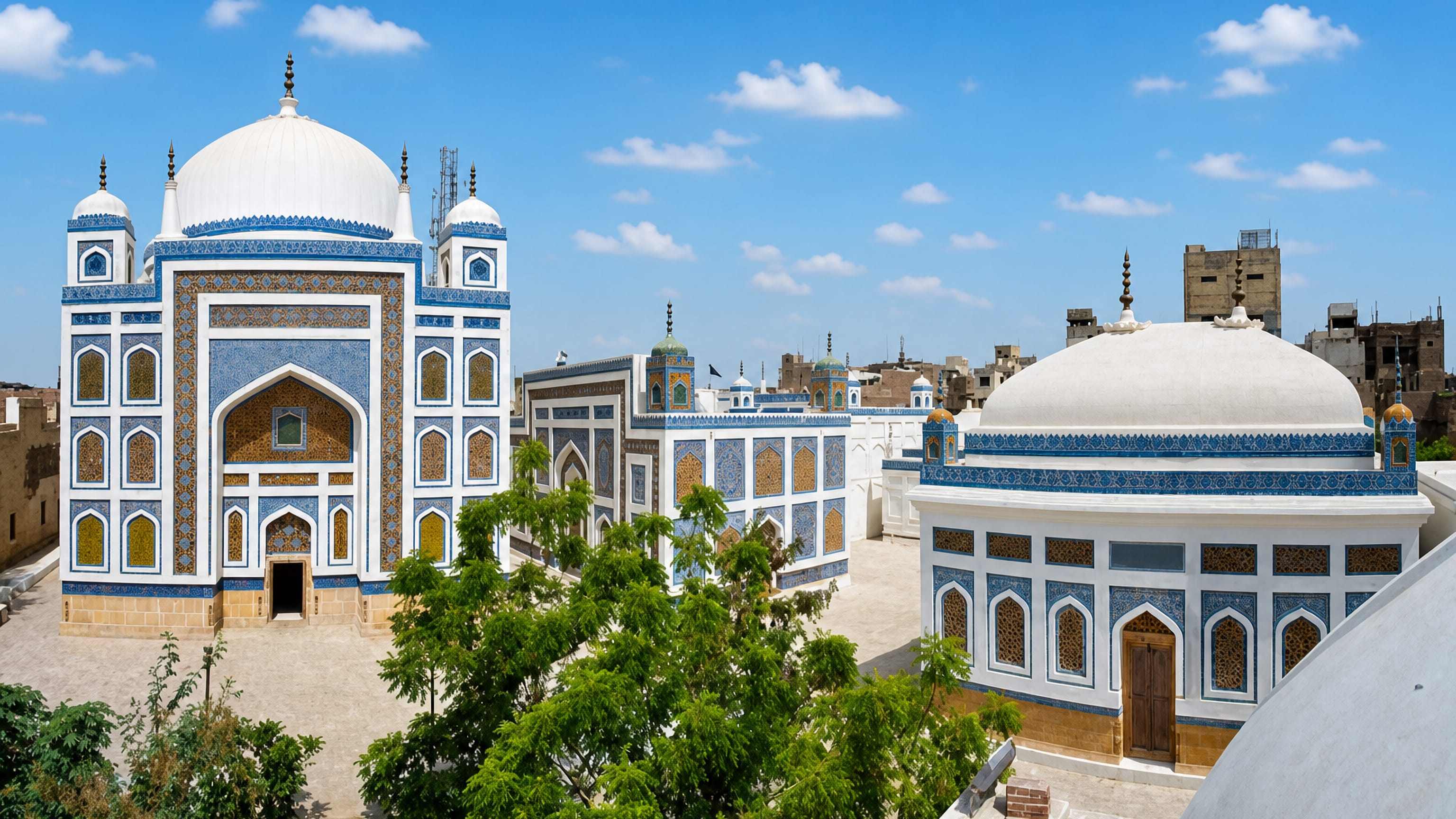 Blue-tiled Talpur Mir tombs with white domes above the old city rooftops of Hyderabad, Sindh, Pakistan.