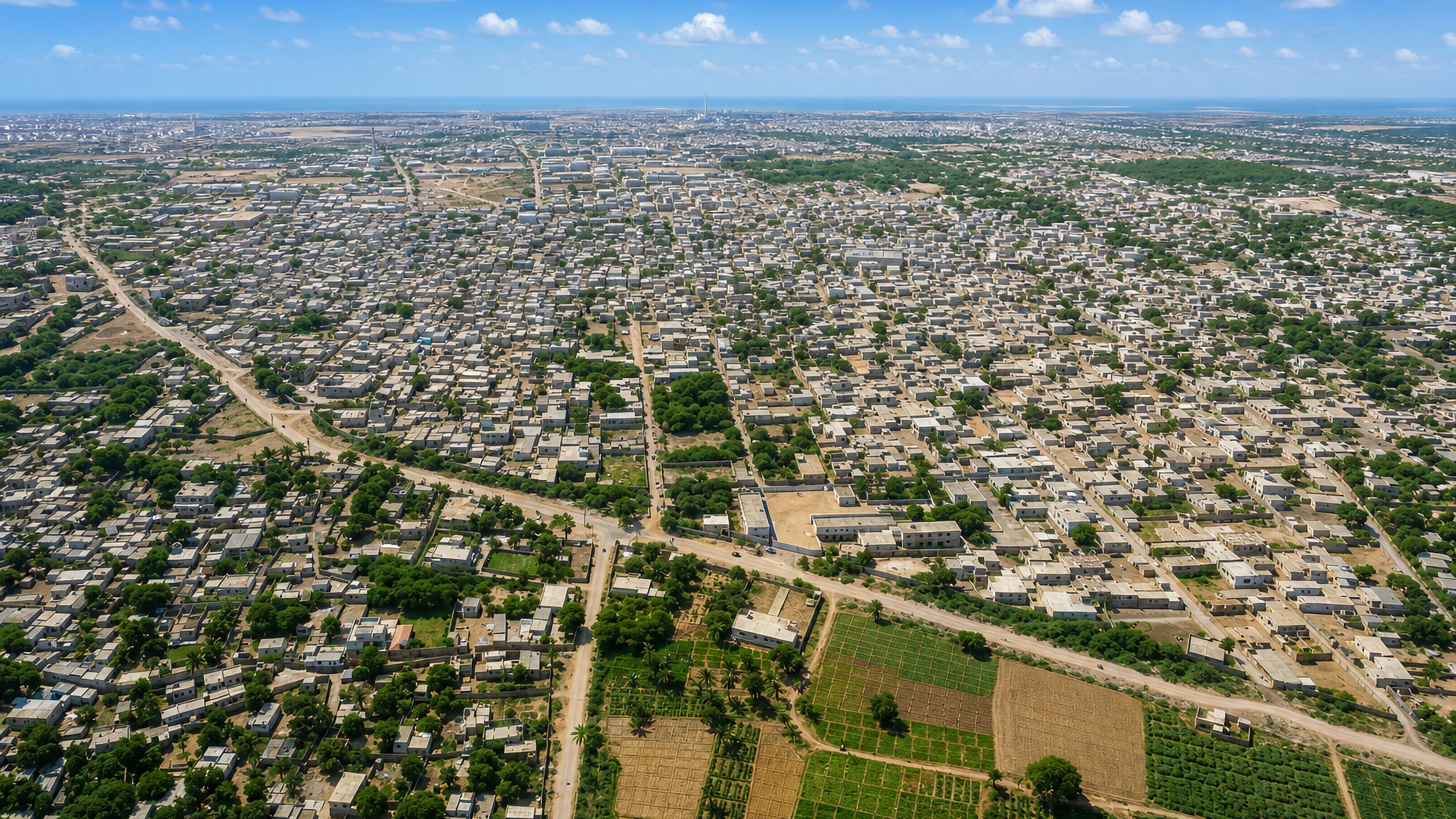 Aerial view of low-rise housing and farm plots spreading across Malir Town on the edge of Karachi.