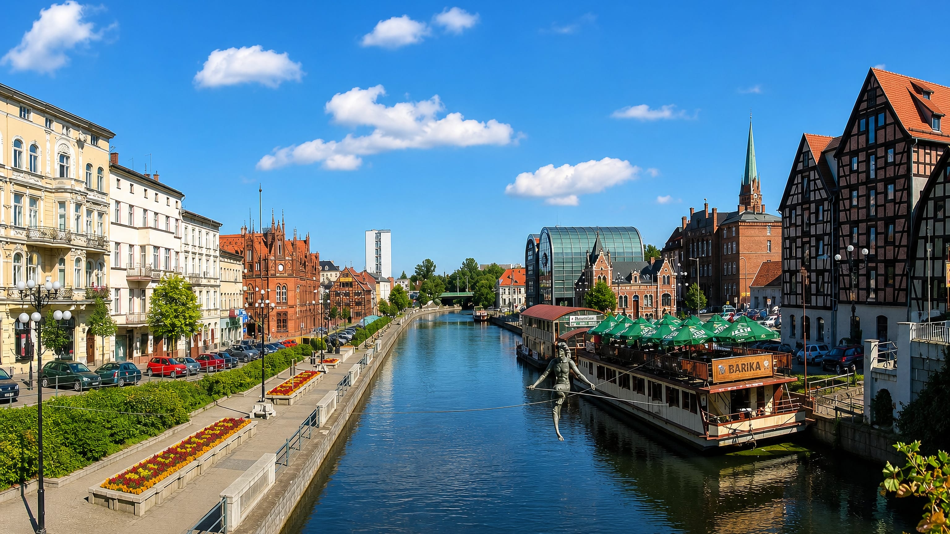 Bydgoszcz's Brda River waterfront with half-timbered granaries, historic townhouses and the tightrope-walker sculpture.