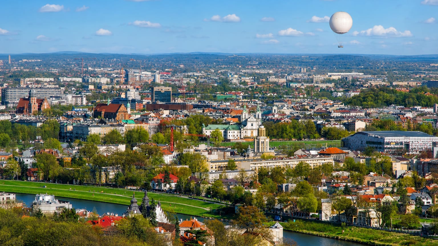 Panorama of Krakow from Debniki across the Vistula River showing the old town, church domes and a tourist balloon