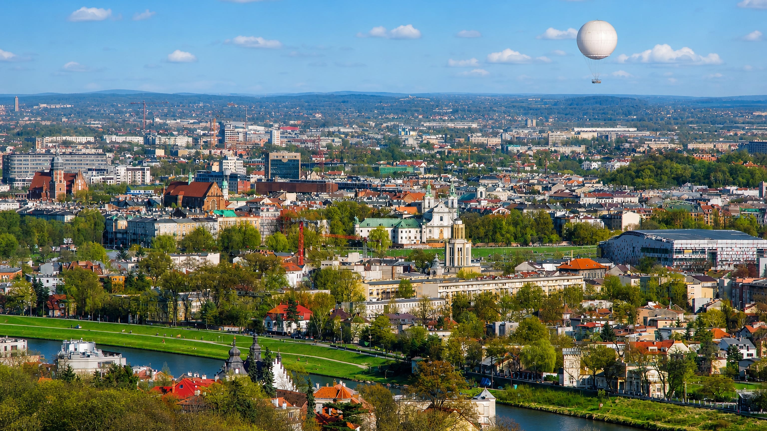 Panorama of Krakow from Debniki across the Vistula River showing the old town, church domes and a tourist balloon