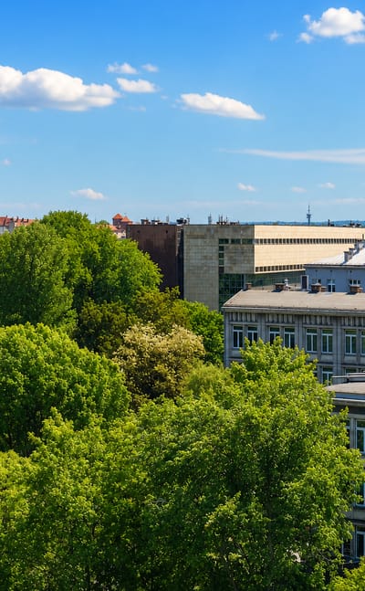Rooftops and greenery of Krowodrza with the spires of Wawel Castle rising on the Krakow skyline behind