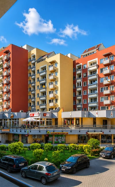 Street-level view of a colourful modern housing and retail estate in the Gądów Mały district of Wrocław.
