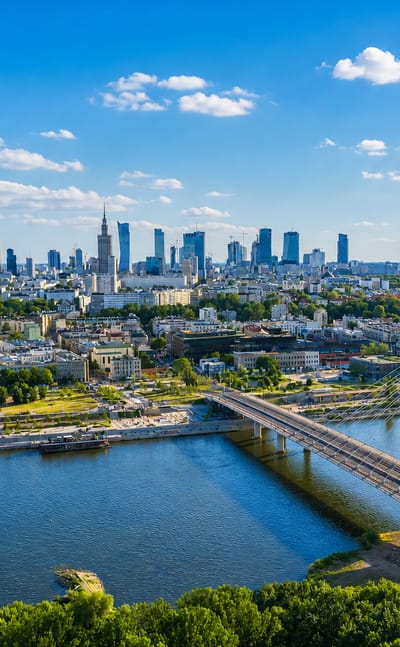 Warsaw skyline across the Vistula with the Palace of Culture spire, modern towers and the Swietokrzyski bridge