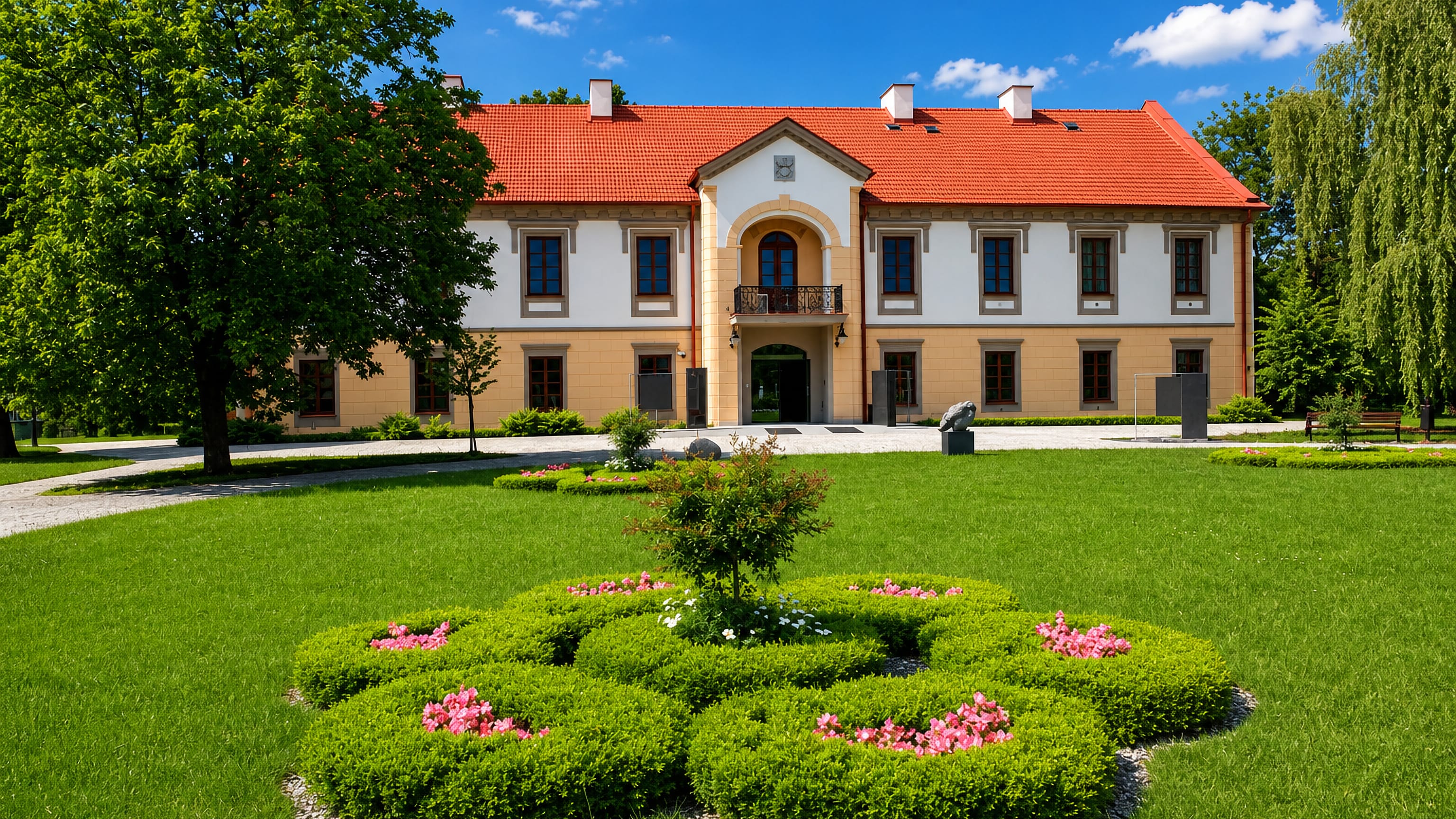 Classicist palace with orange tiled roof and formal flowerbed garden in Rozwadów, Stalowa Wola.