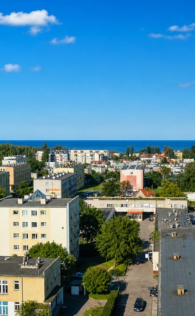 View over the seaside Brzeźno district of Gdańsk with apartment blocks and the Baltic Sea on the horizon.