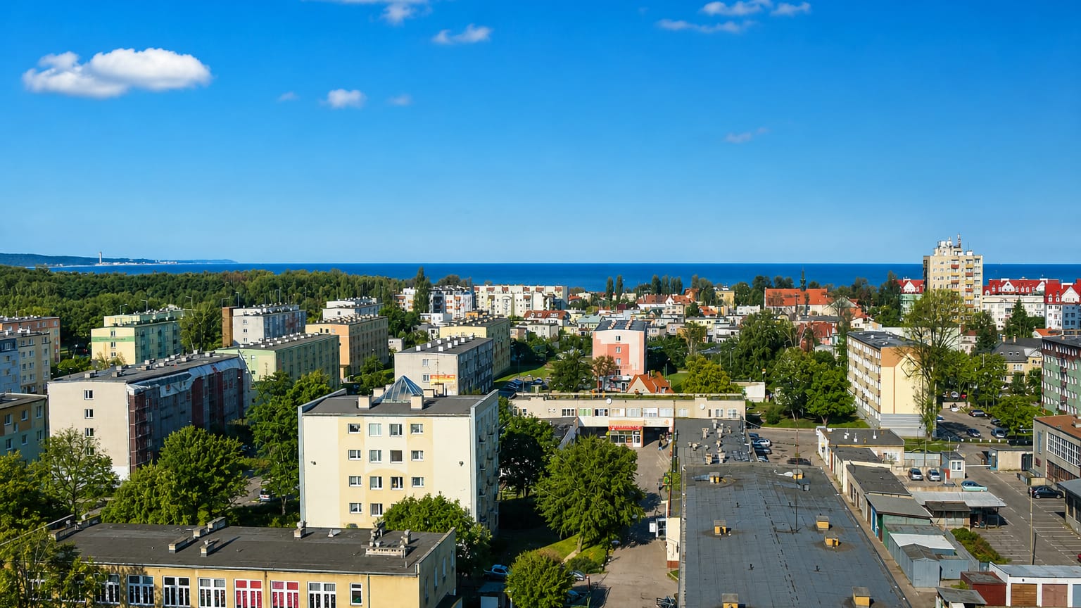 View over the seaside Brzeźno district of Gdańsk with apartment blocks and the Baltic Sea on the horizon.