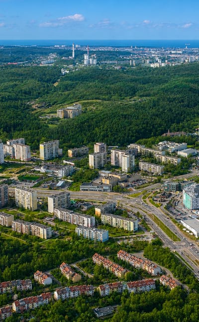 Aerial of the large Piecki-Migowo housing estate in Gdansk with forest and the bay on the horizon.