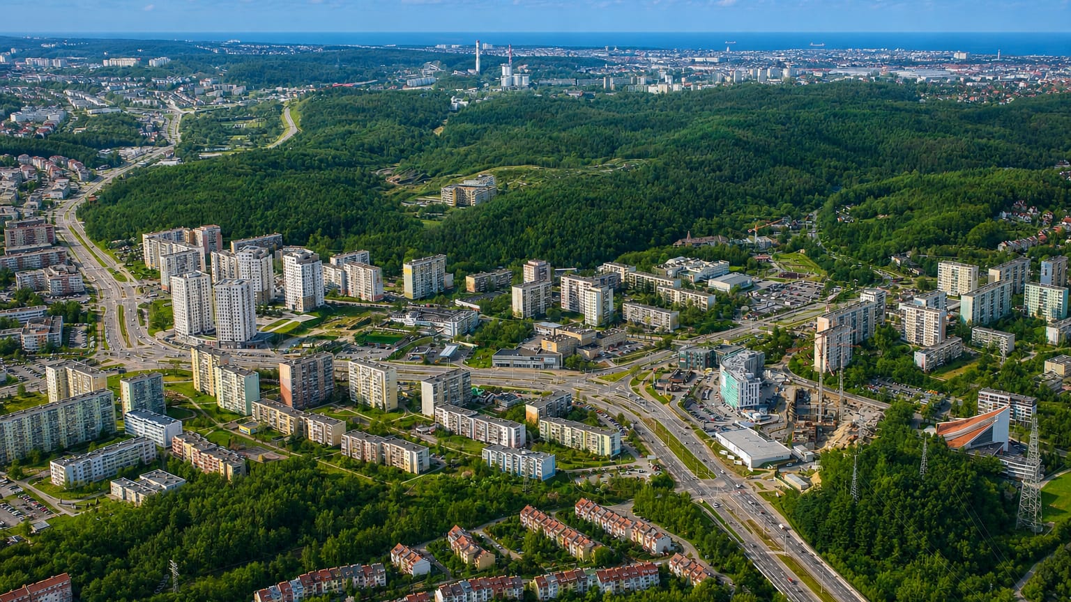 Aerial of the large Piecki-Migowo housing estate in Gdansk with forest and the bay on the horizon.