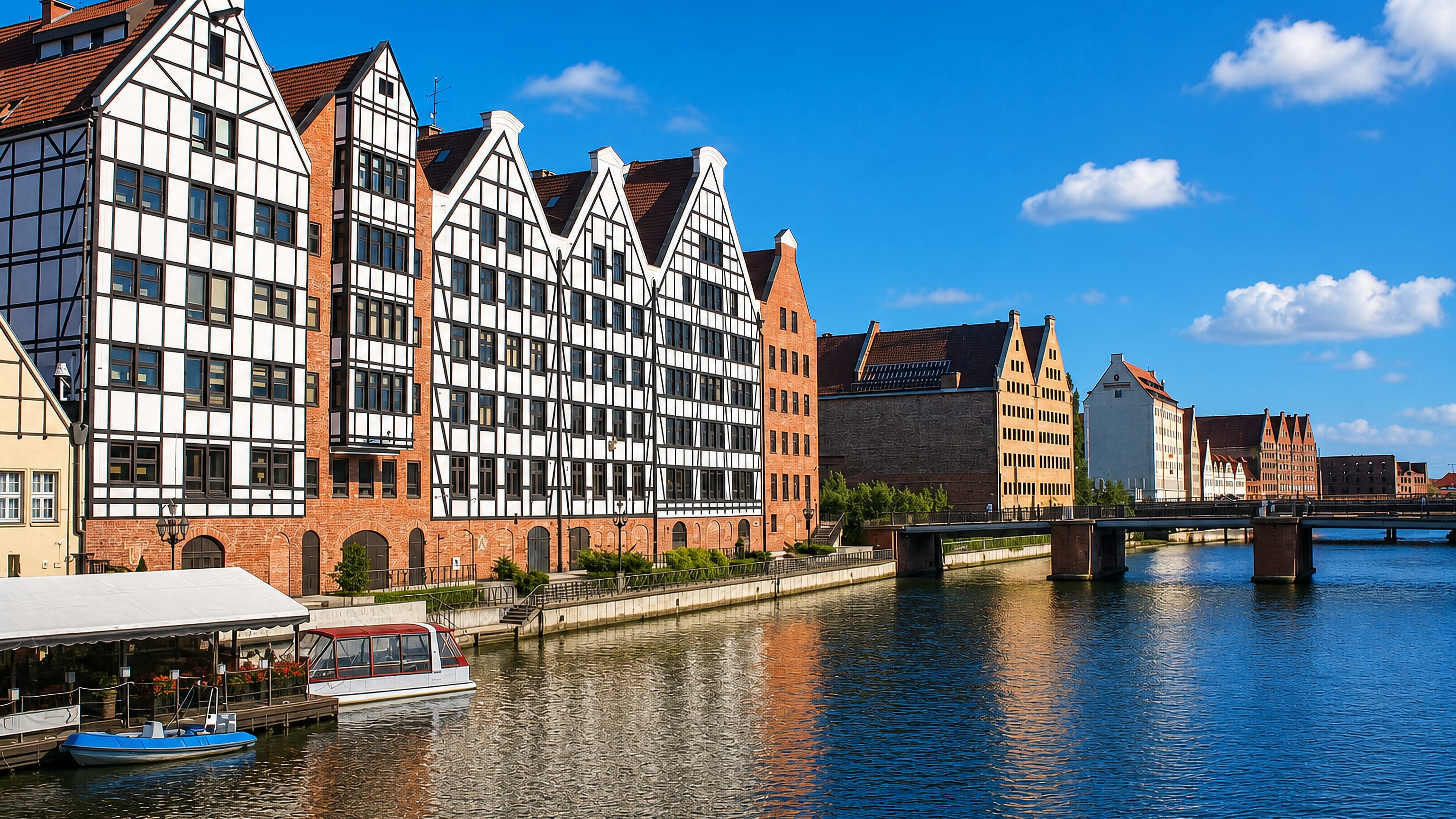 Half-timbered brick granaries lining the Motlawa waterfront in Srodmiescie, Gdansk, on a clear day
