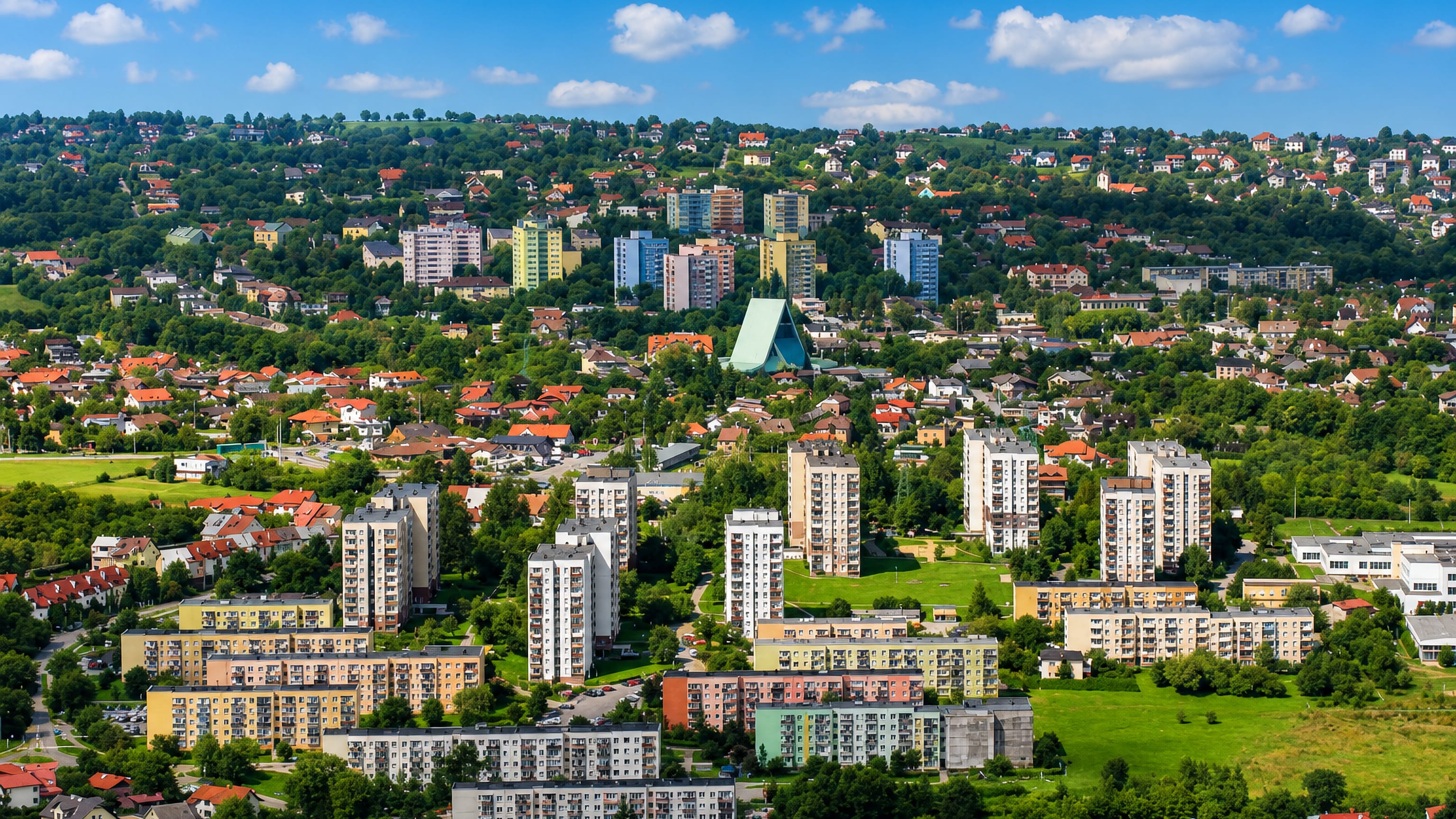 Apartment blocks and houses of the Beskidzkie estate spread below wooded foothills in Bielsko-Biała.