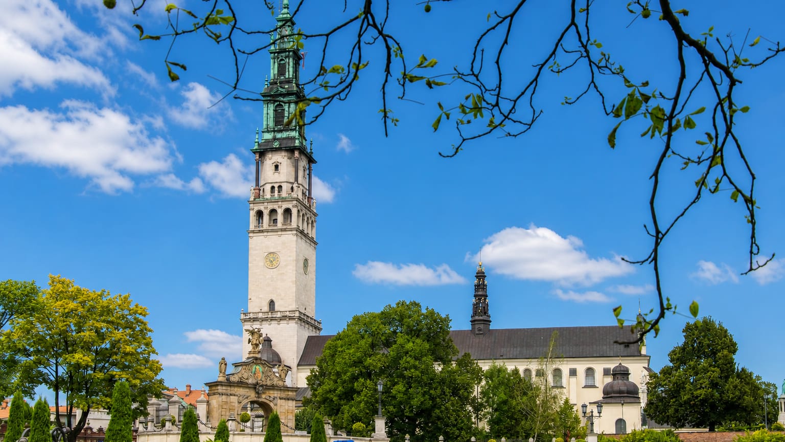 Jasna Góra Monastery in Częstochowa, its Baroque tower and green spire rising above manicured gardens.