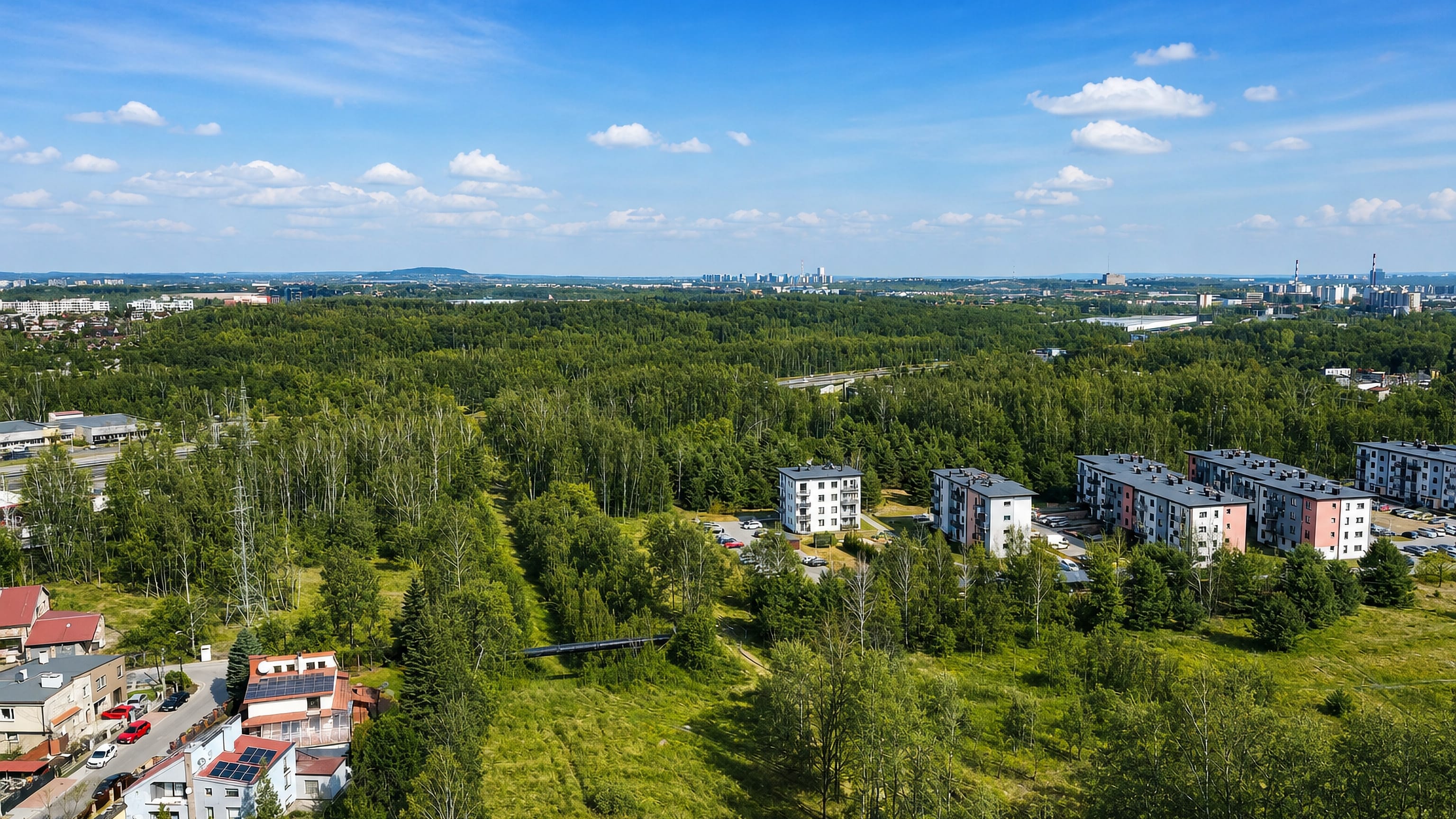 Woodland and low apartment blocks of Szopienice with the Katowice skyline on the horizon.