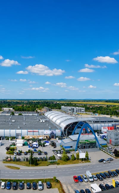 The Targi Kielce exhibition centre in Kielce, its arched hall and entrance fronted by a large car park.