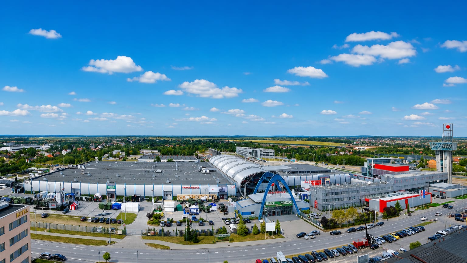 The Targi Kielce exhibition centre in Kielce, its arched hall and entrance fronted by a large car park.