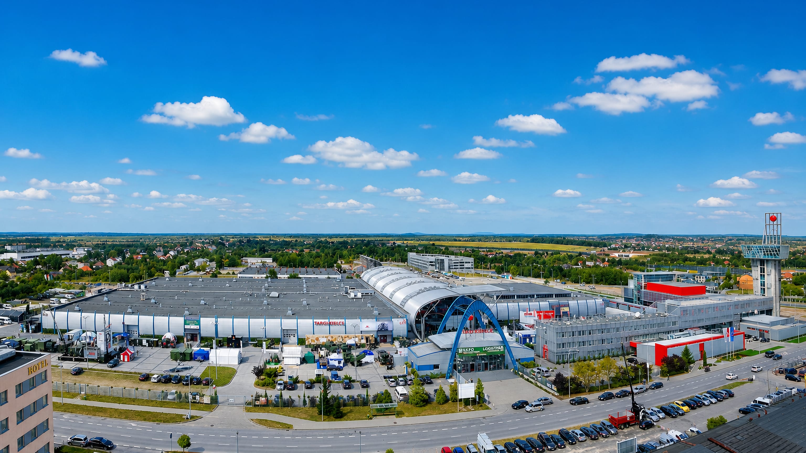The Targi Kielce exhibition centre in Kielce, its arched hall and entrance fronted by a large car park.