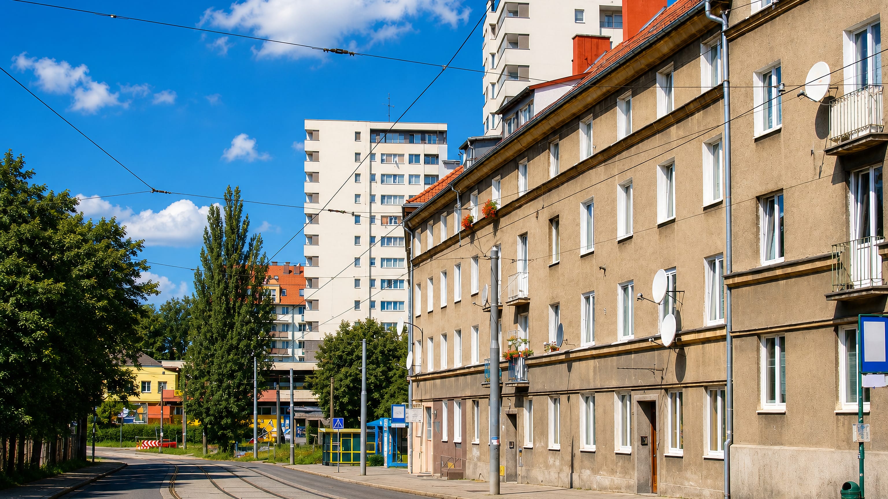 Tram tracks curving past stucco tenements and white tower blocks in Drzetowo-Grabowo, Szczecin