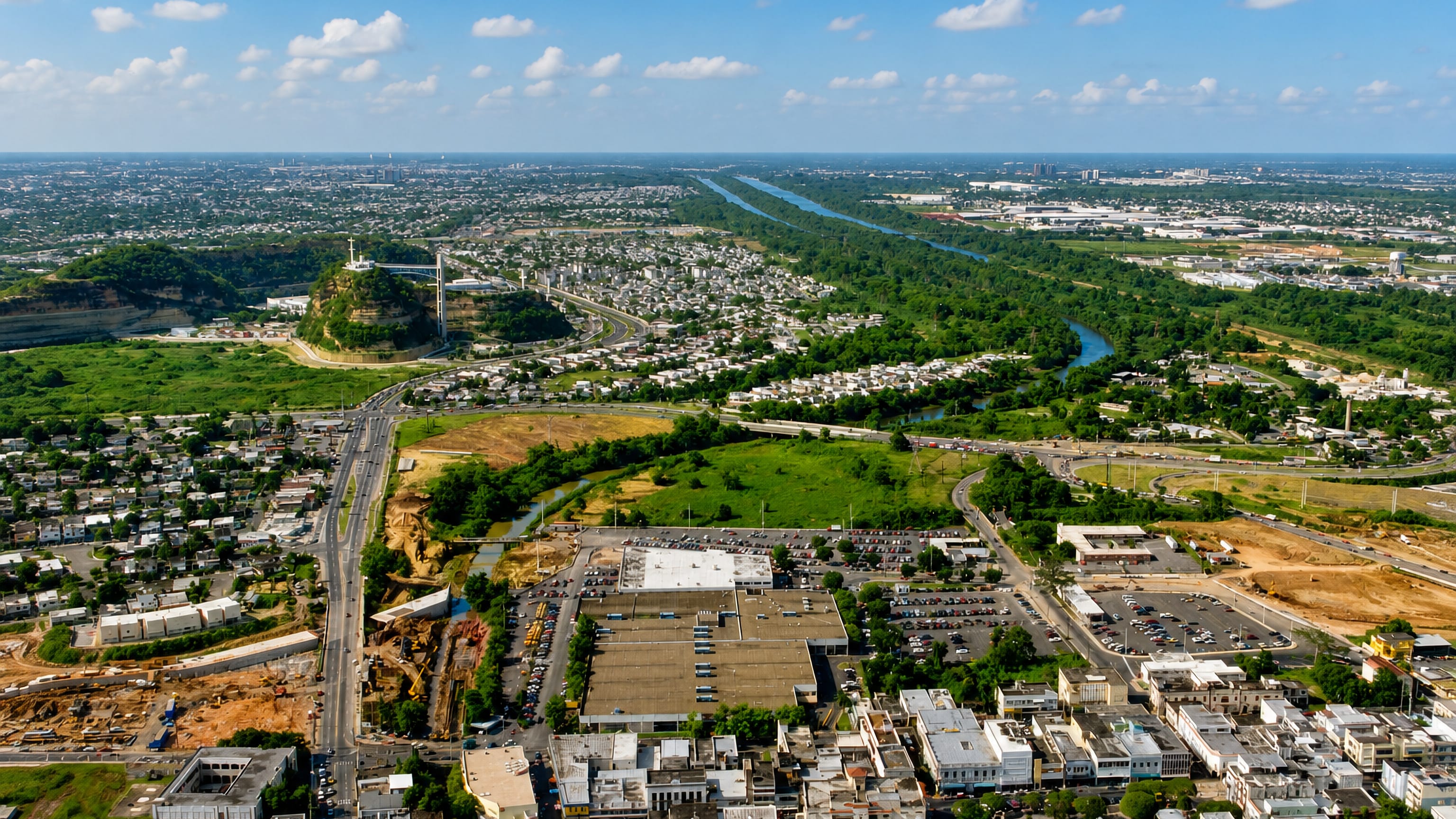 Aerial sweep over Bayamon, Puerto Rico, showing dense neighbourhoods, highways and the Rio Bayamon.