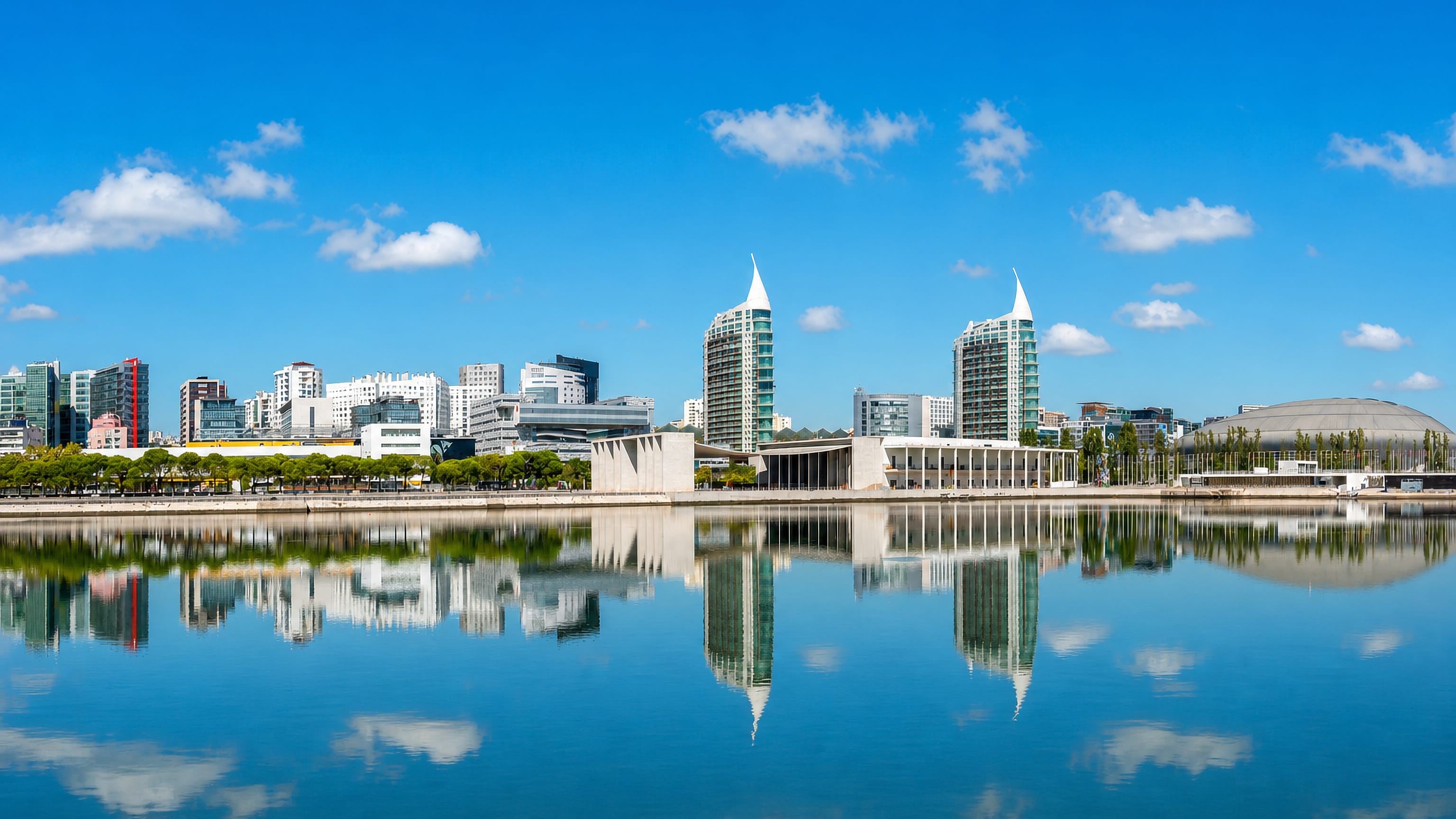 White-tipped São Gabriel and São Rafael towers and the arena dome mirrored in water at Parque das Nações, Lisbon