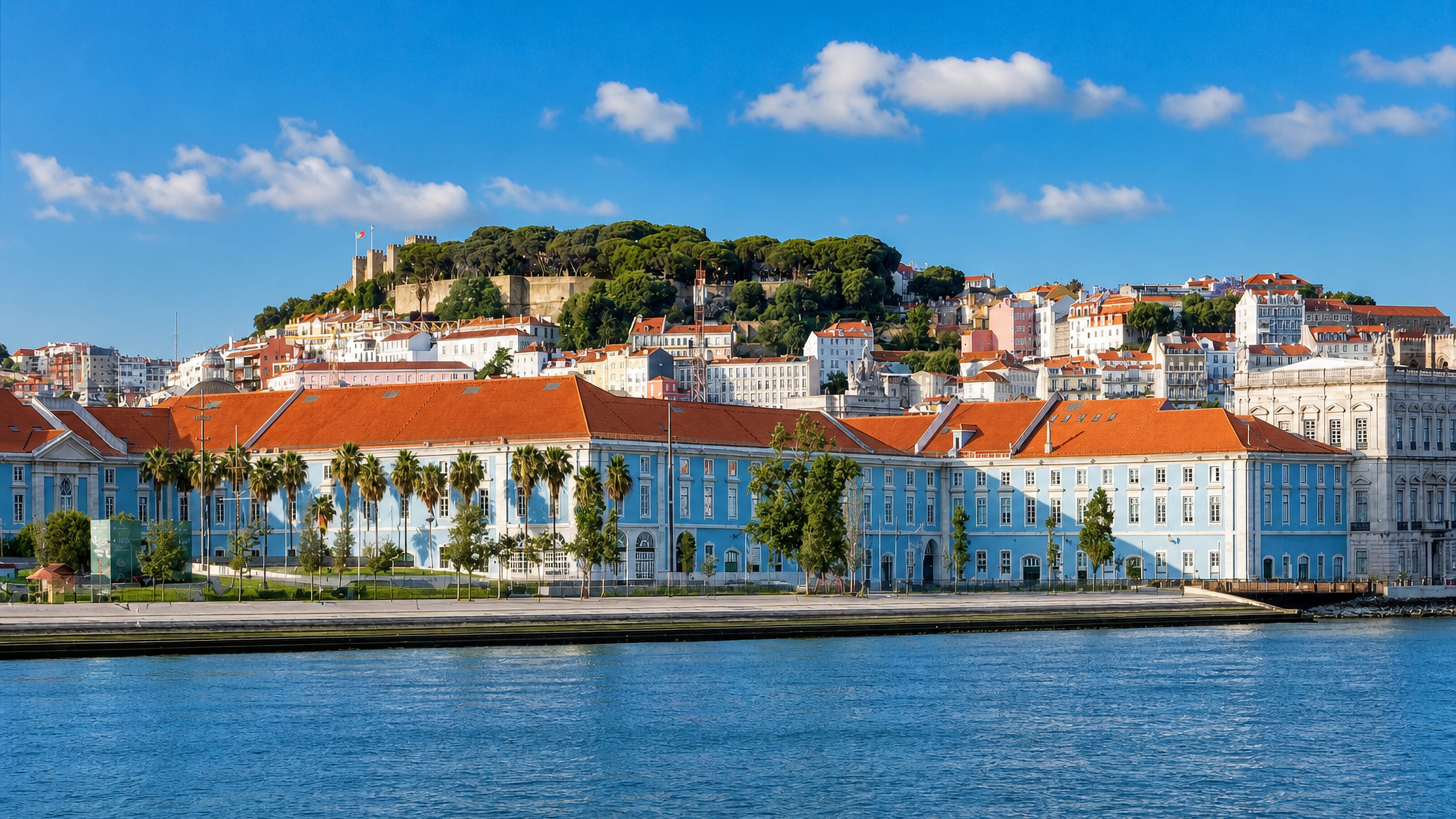 Santa Maria Maior, Lisbon: the Tagus waterfront below Sao Jorge Castle on its wooded hill above red-tiled roofs