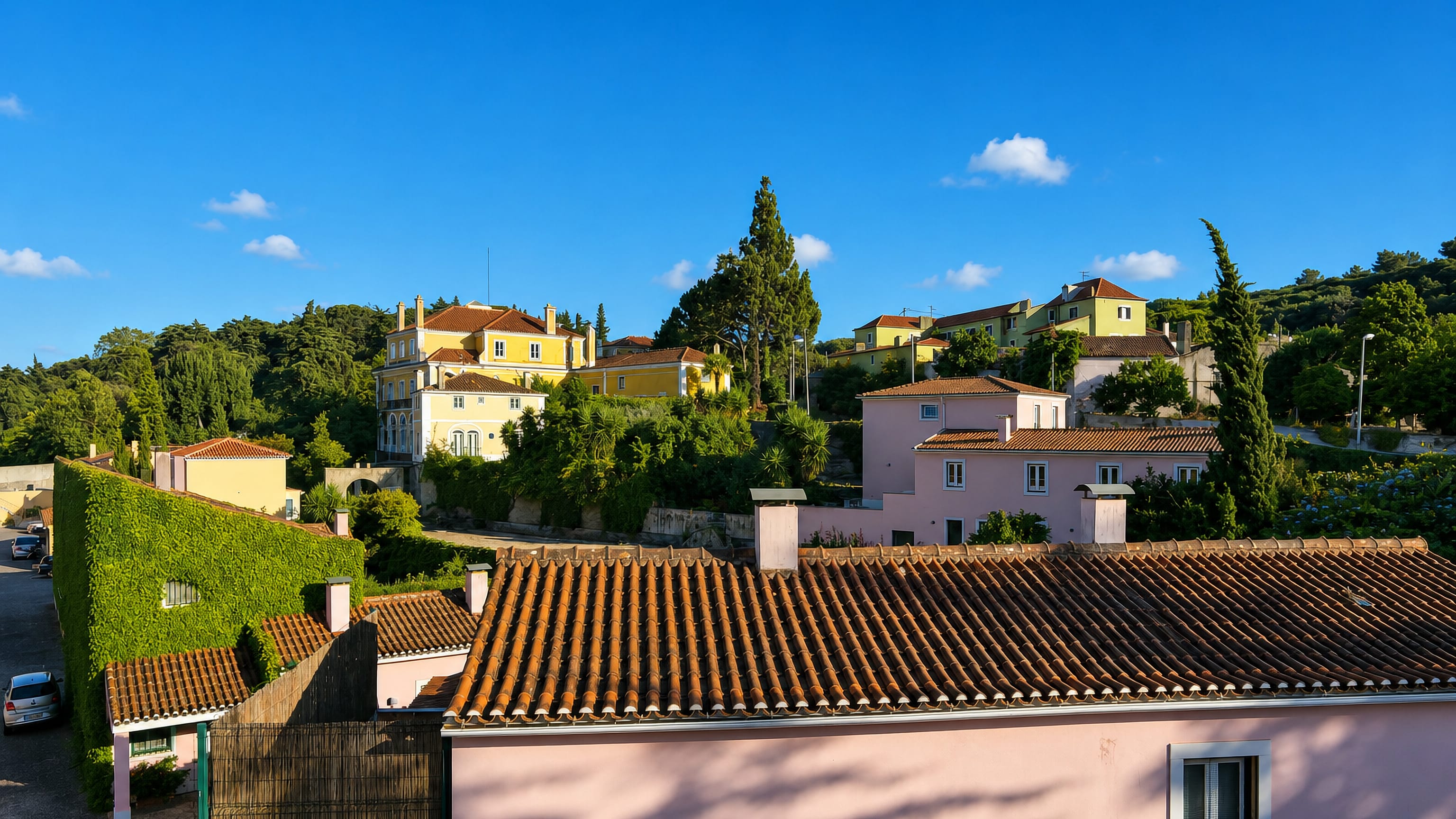 Terracotta rooftops and pastel villas on a wooded slope in Sao Domingos de Benfica, Lisbon