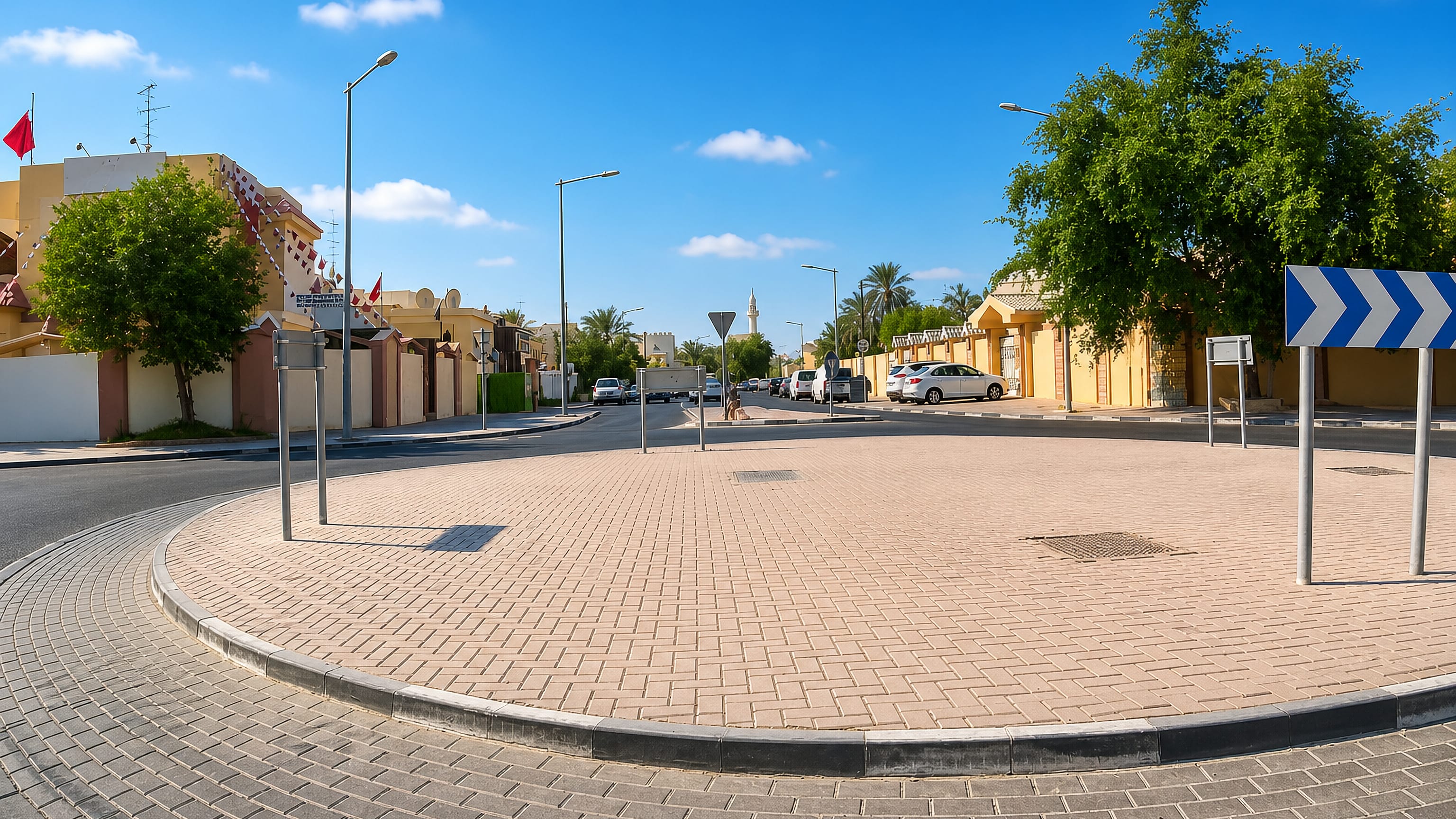 Palm-lined street and roundabout among walled villas in Al Hilal al Gharbiyah, Doha.