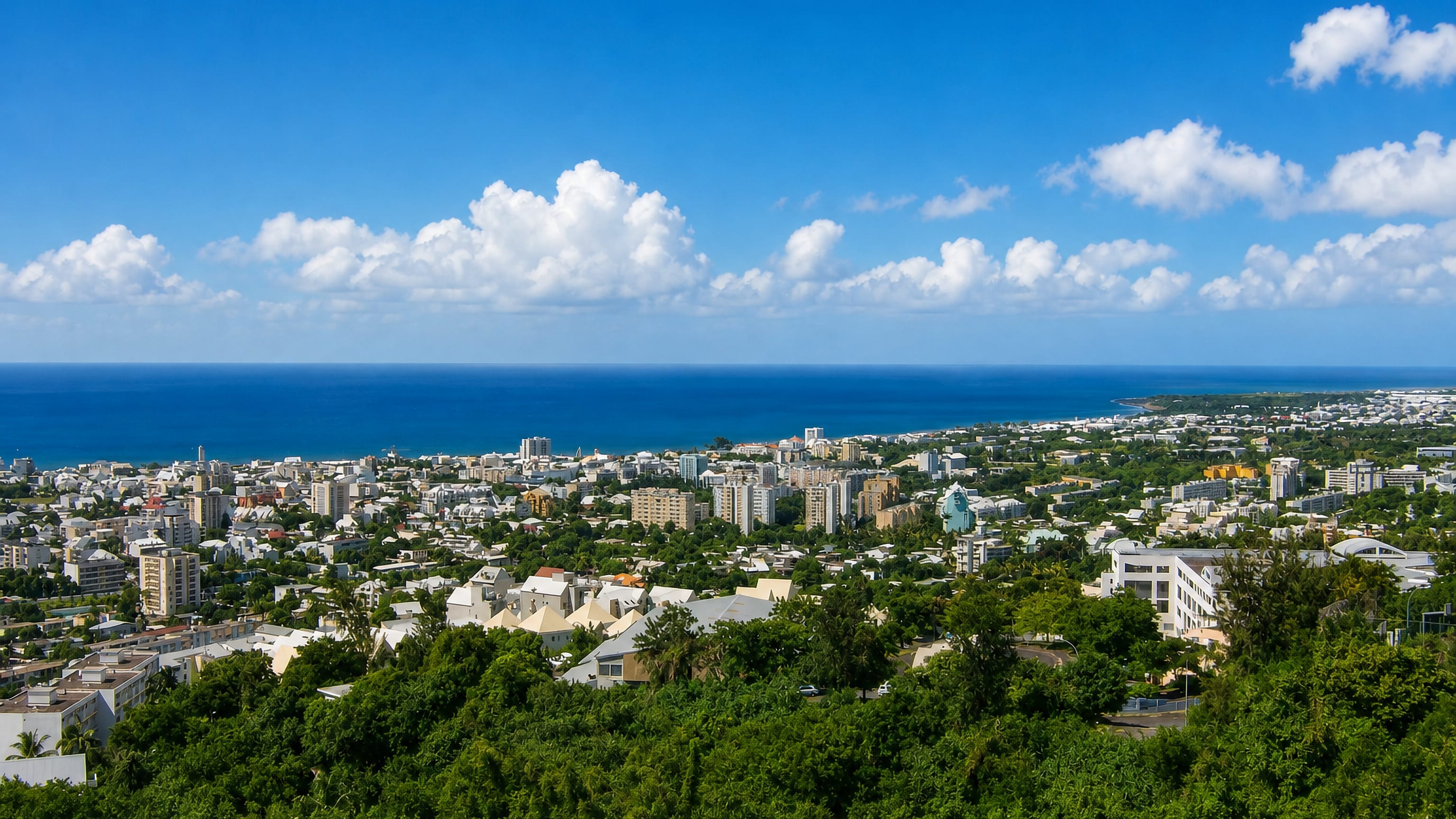Hillside view over the rooftops and towers of Saint-Denis, Reunion, stretching to the Indian Ocean coast.