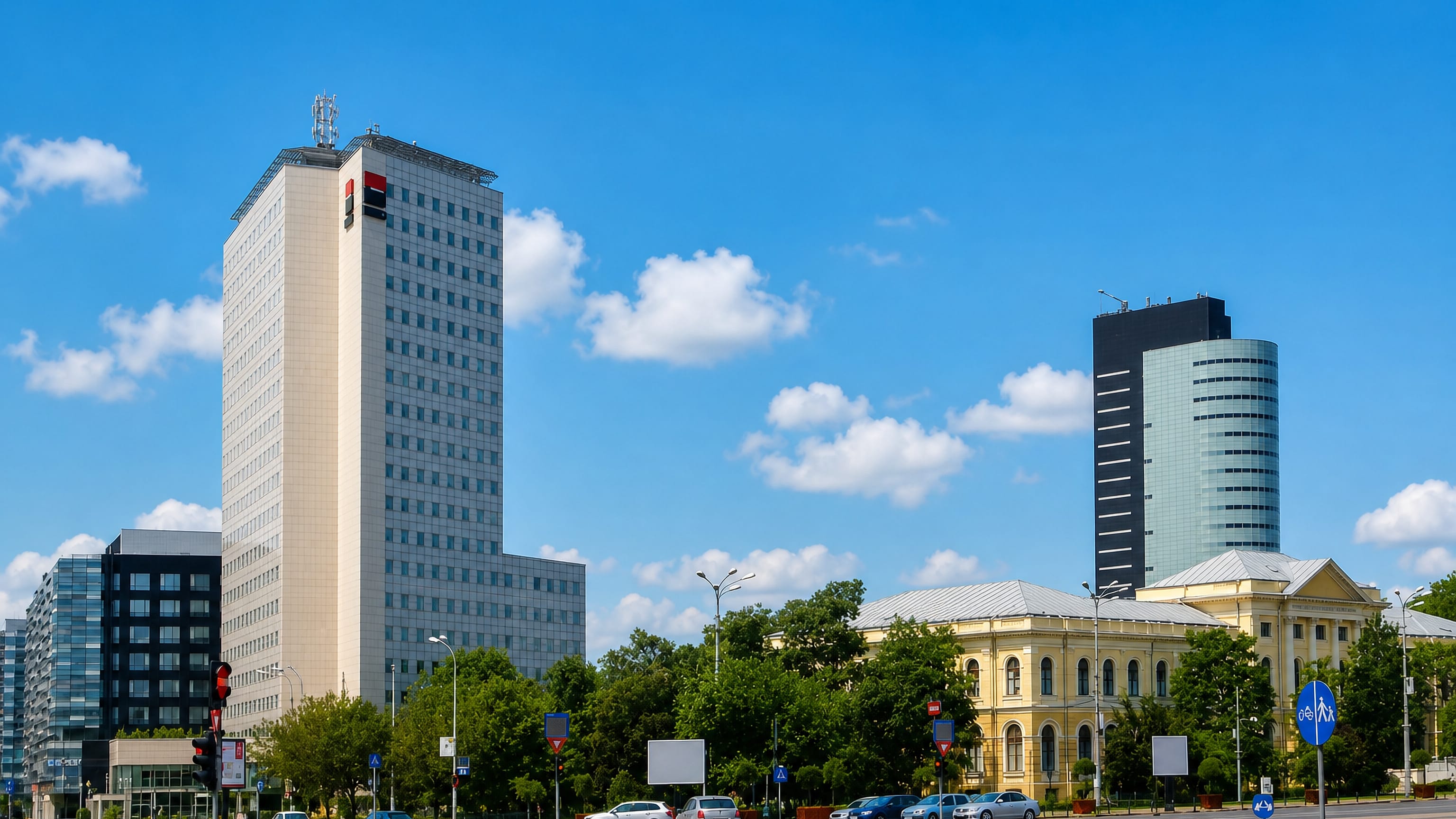 Wide boulevard in Bucharest's Sector 1 lined with modern office towers and a neoclassical building.