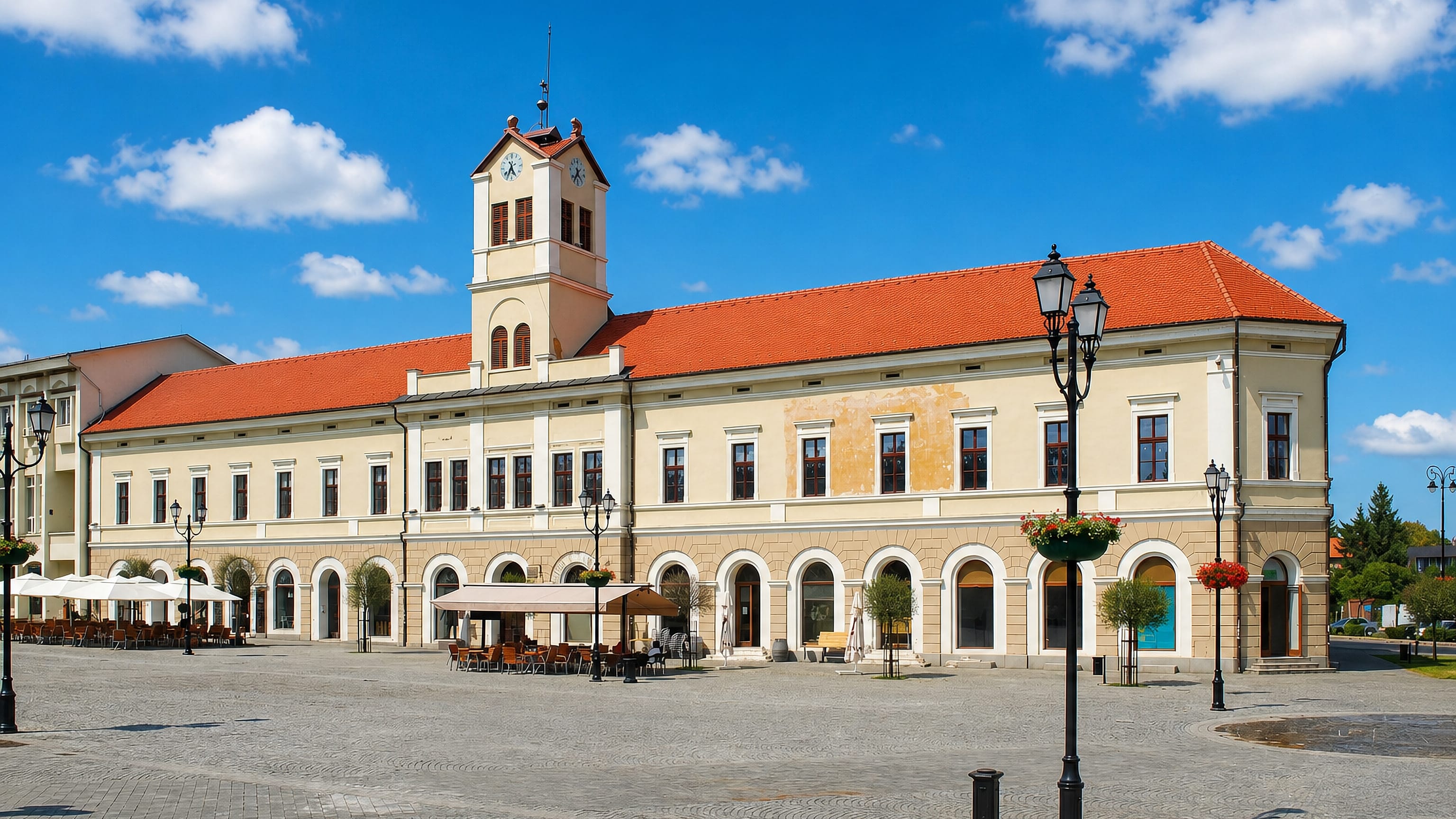 An arcaded, red-roofed clock-tower building on the main square of Sfantu Gheorghe, Romania