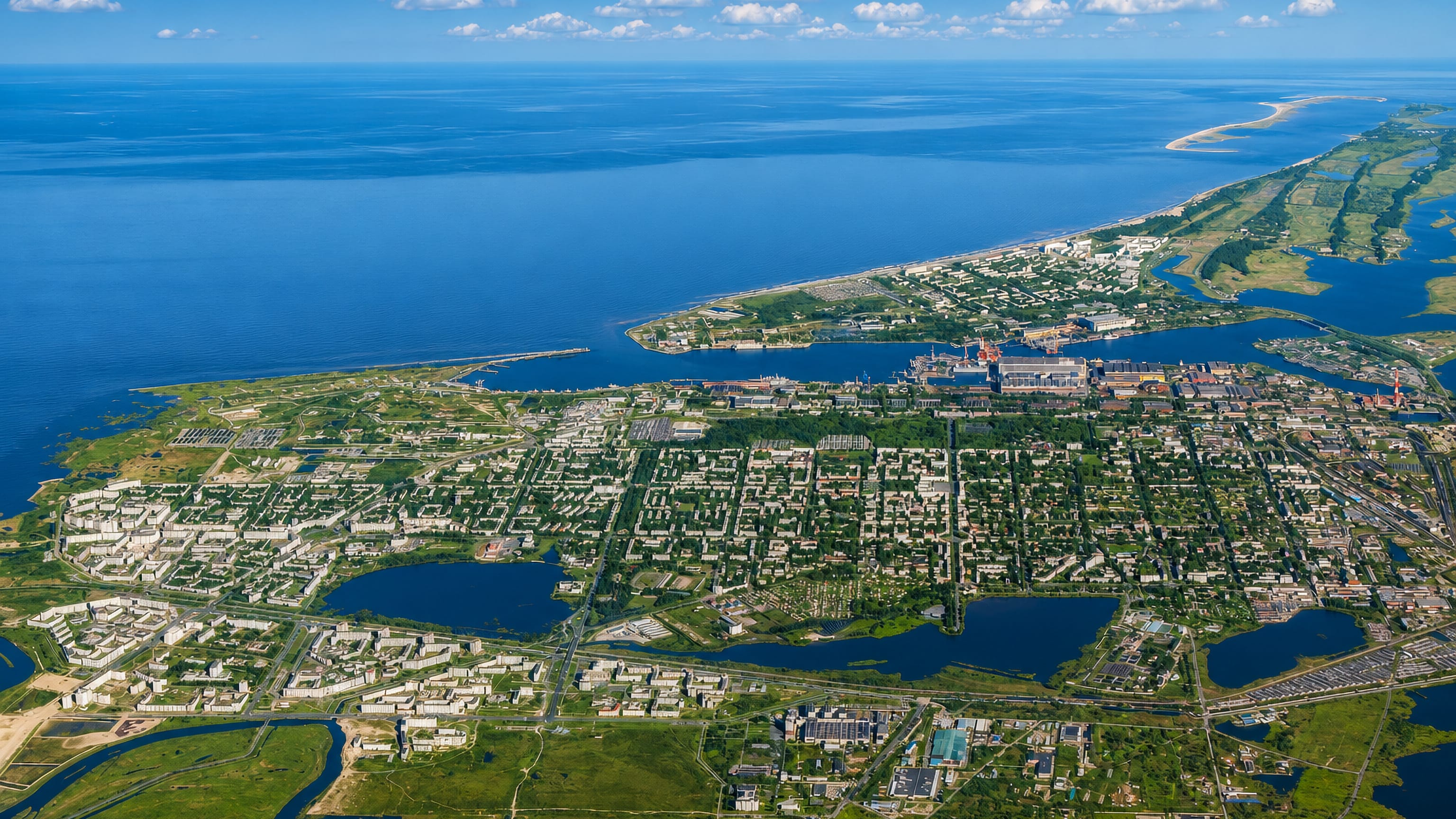 Severodvinsk, Russia, from the air: low-rise blocks, lakes and shipyard cranes along the White Sea estuary.