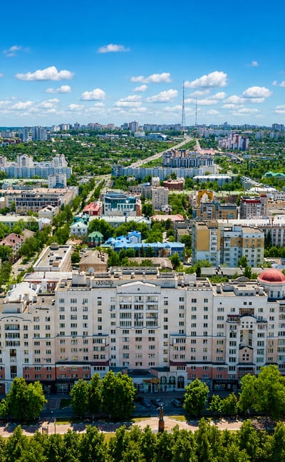 Aerial view over Belgorod's tree-lined avenues and a domed neoclassical apartment block in summer