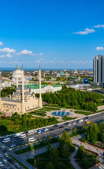 Grozny skyline with the golden-domed Akhmad Kadyrov Mosque and the Grozny City tower cluster under a clear blue sky