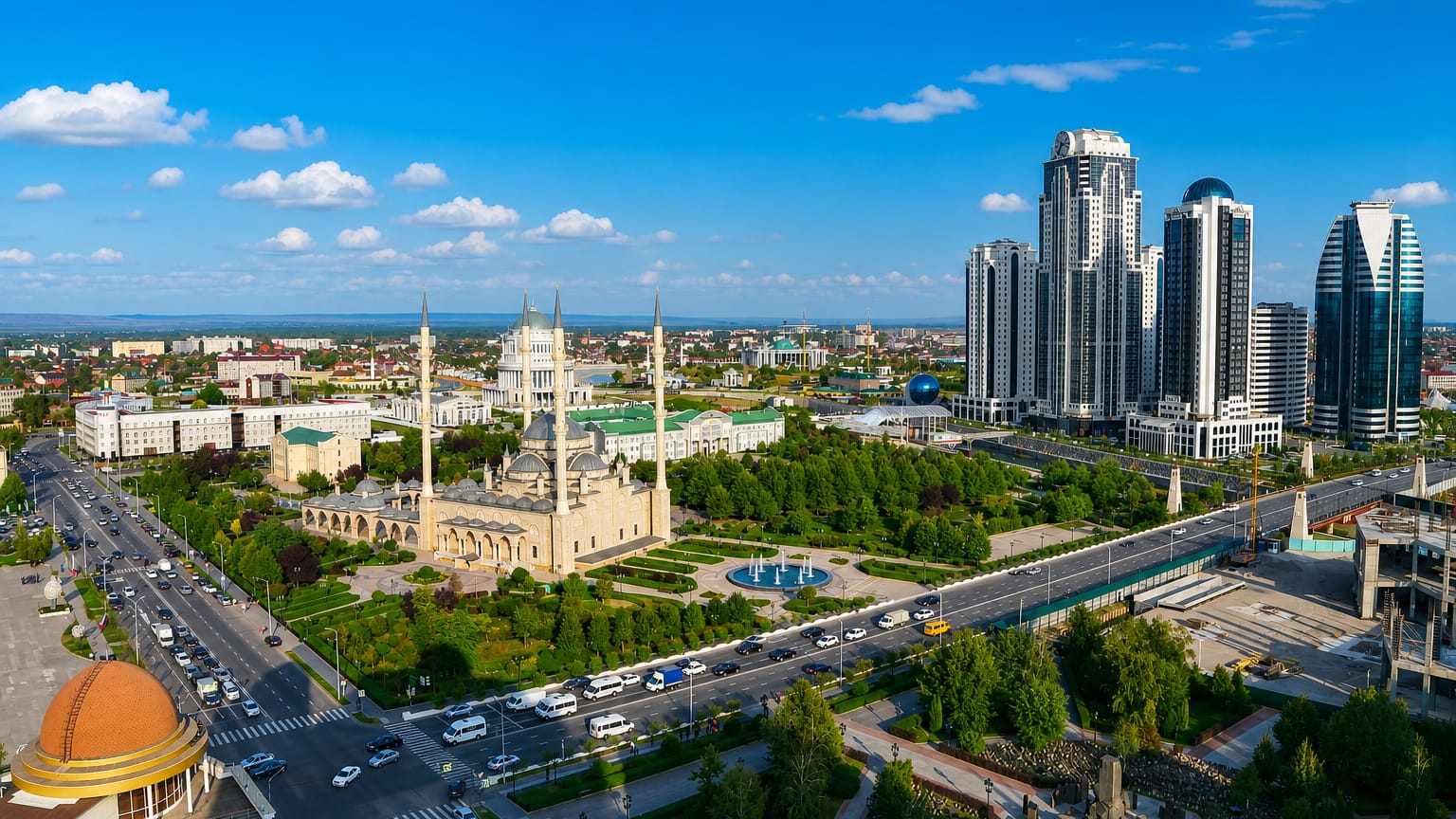 Grozny skyline with the golden-domed Akhmad Kadyrov Mosque and the Grozny City tower cluster under a clear blue sky
