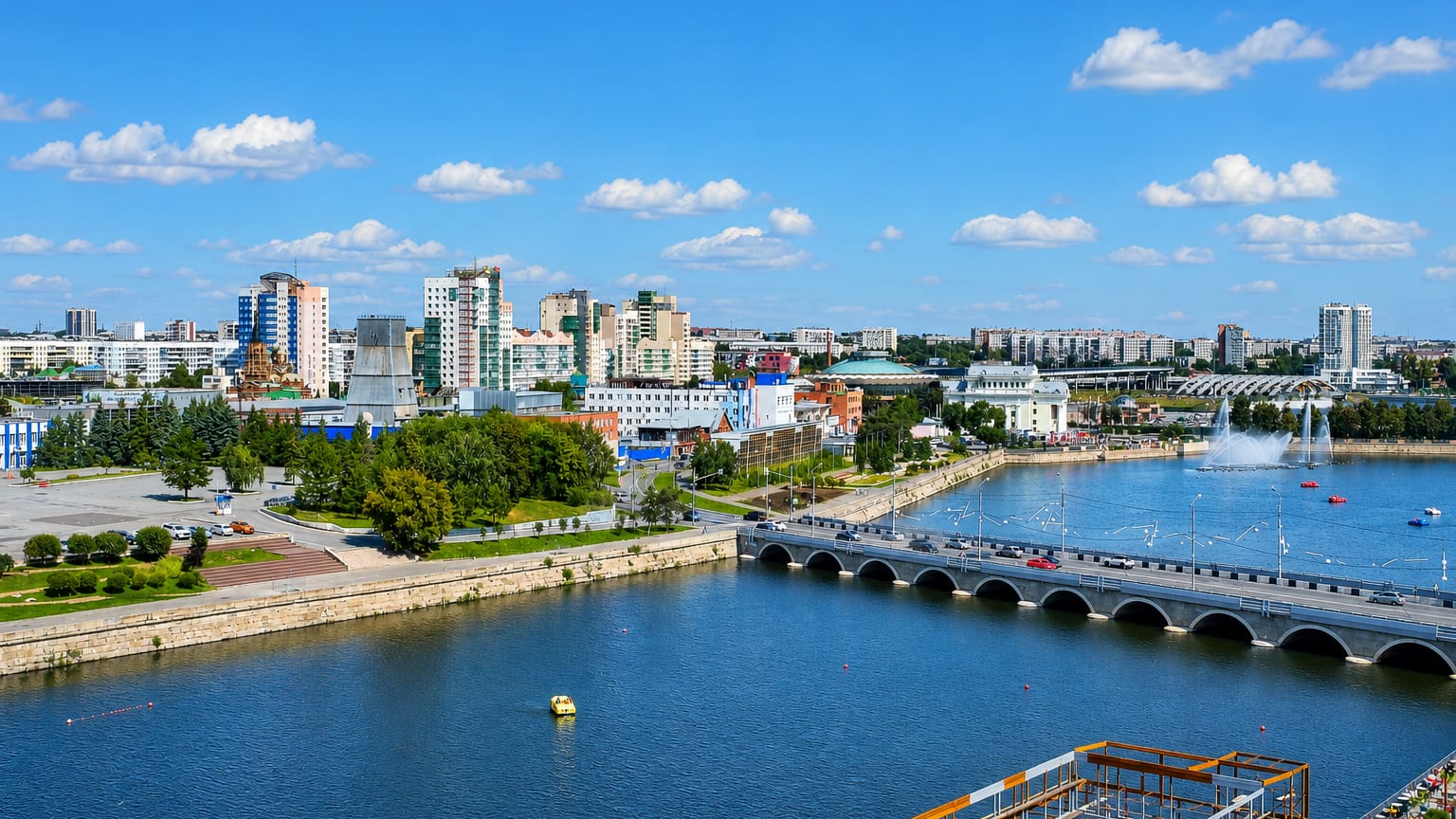 Riverfront city view with an arched bridge, fountains and skyline across the water in Chelyabinsk, Russia