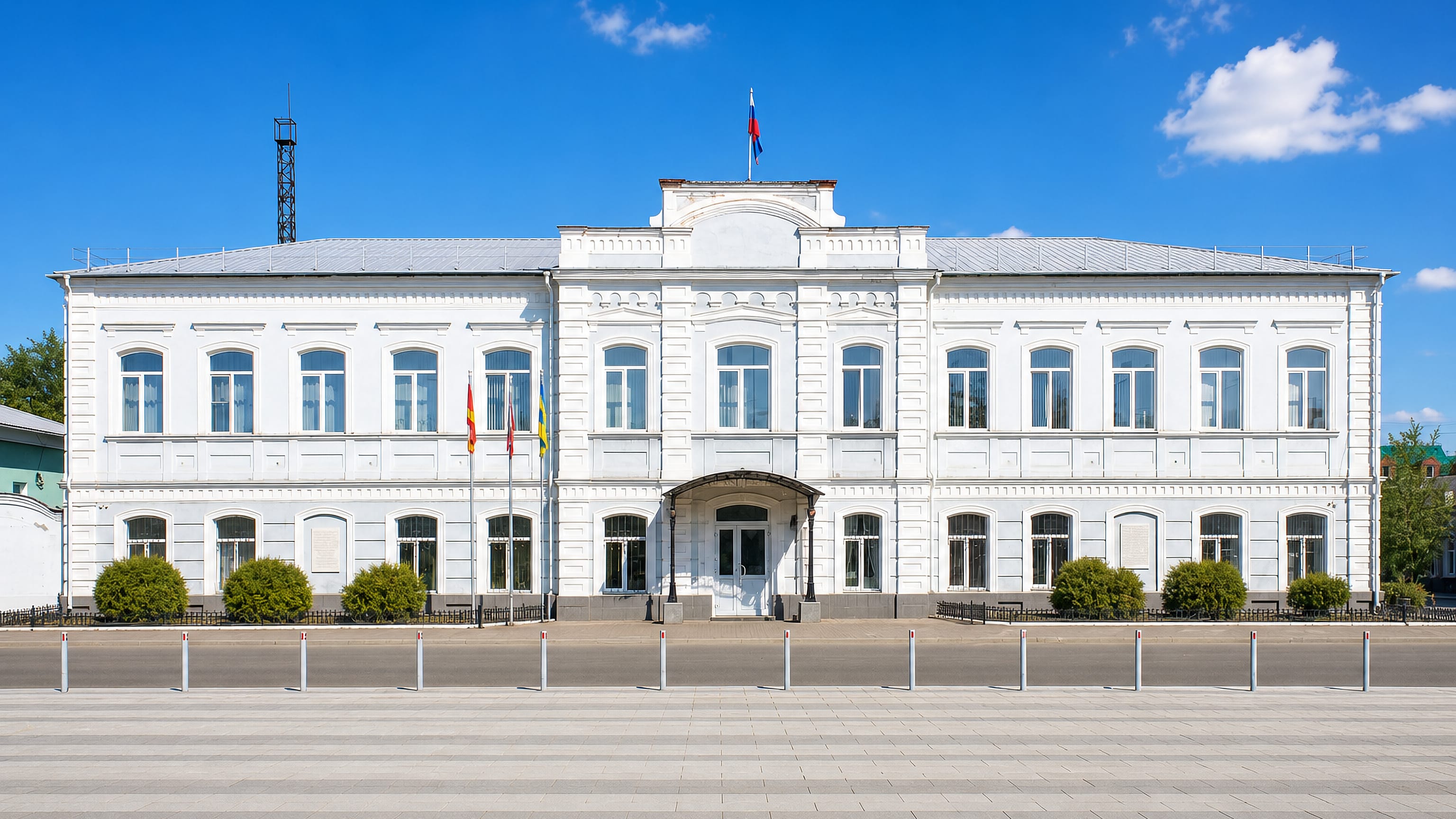 Neoclassical white civic building with the Russian flag facing a paved square in Troitsk, Chelyabinsk Oblast