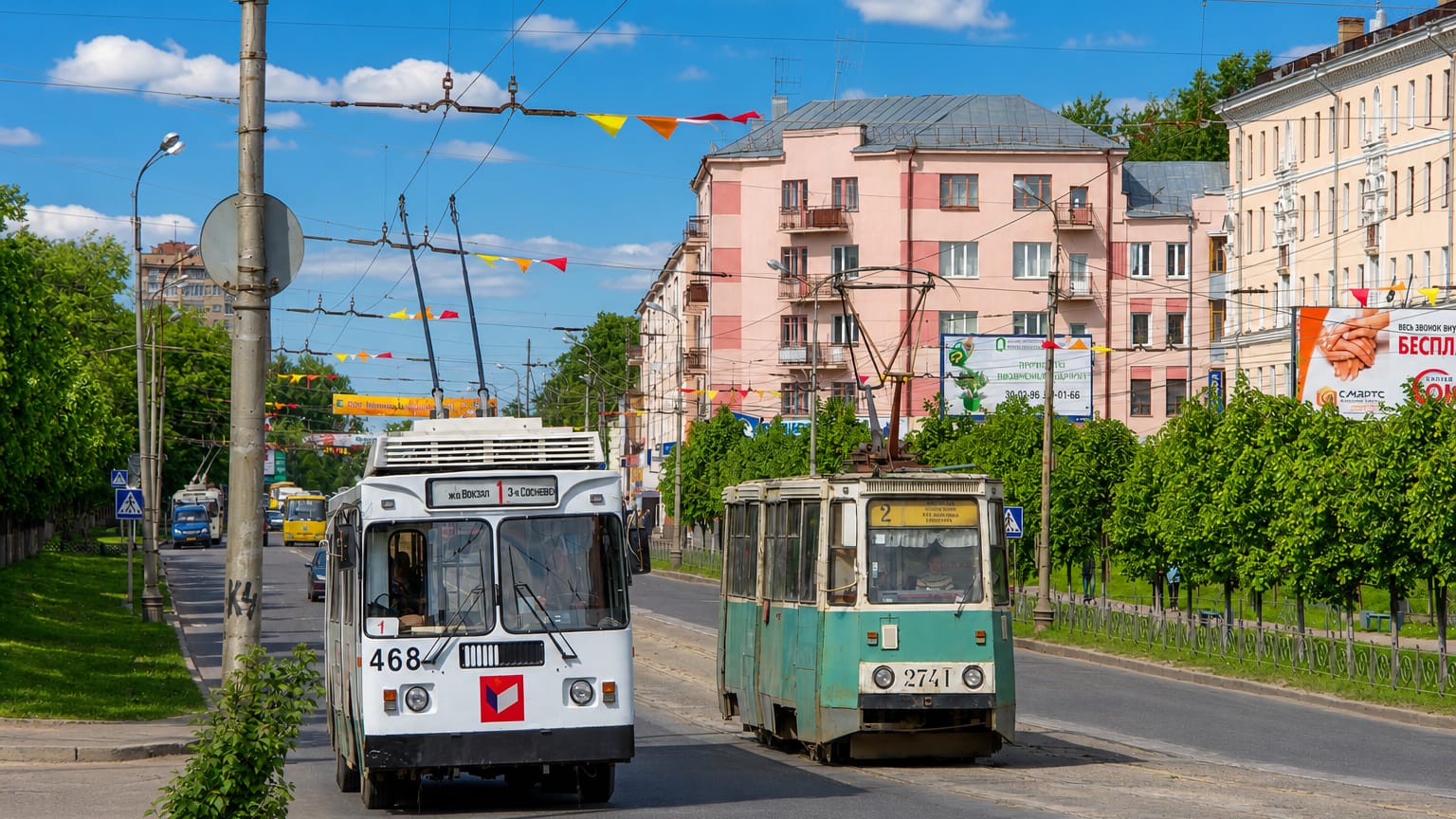 Ivanovo street scene with a white trolleybus and tram passing pastel apartment buildings under festive flags.