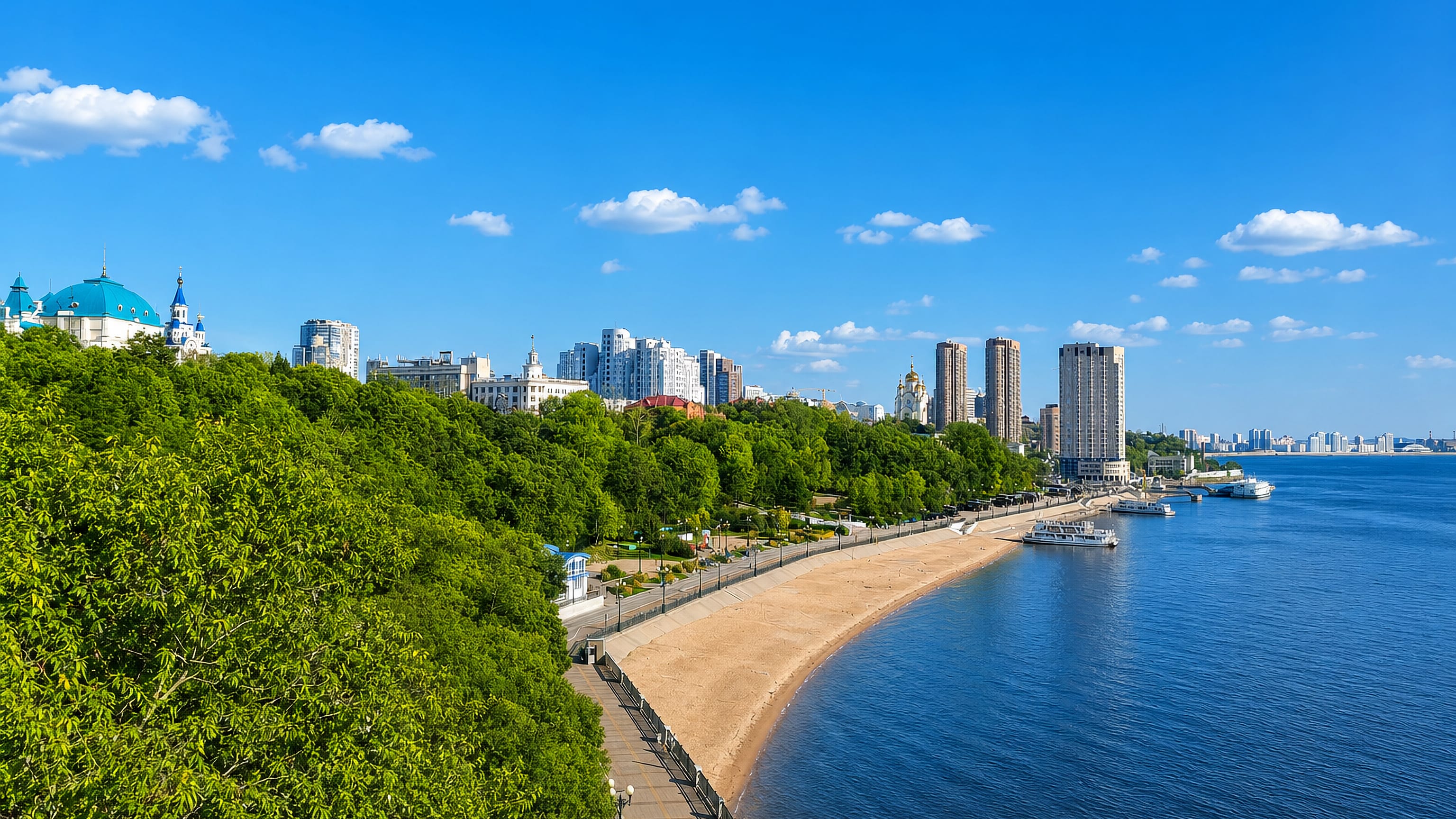 Khabarovsk's Amur River embankment with a sandy city beach, blue-domed cathedral and riverside towers.