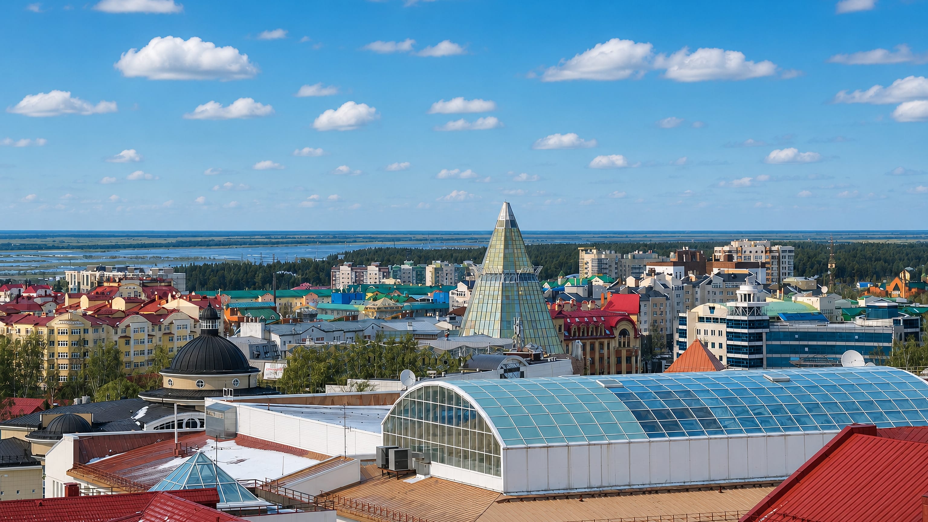 Rooftops of Khanty-Mansiysk, Russia, around the glass pyramid tower, with the Irtysh floodplain beyond.